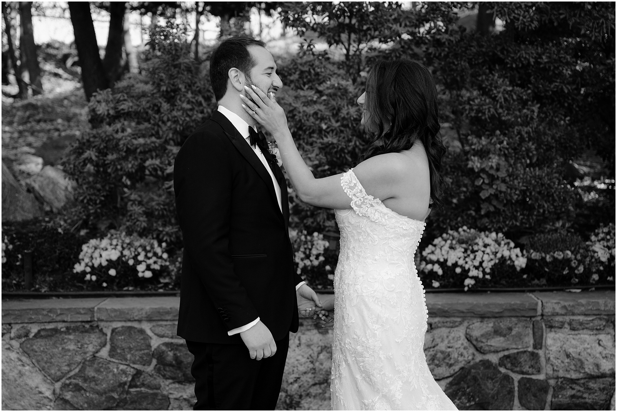bride holds groom's chin smiling at him during first look on stone patio at Tappan Hill Mansion