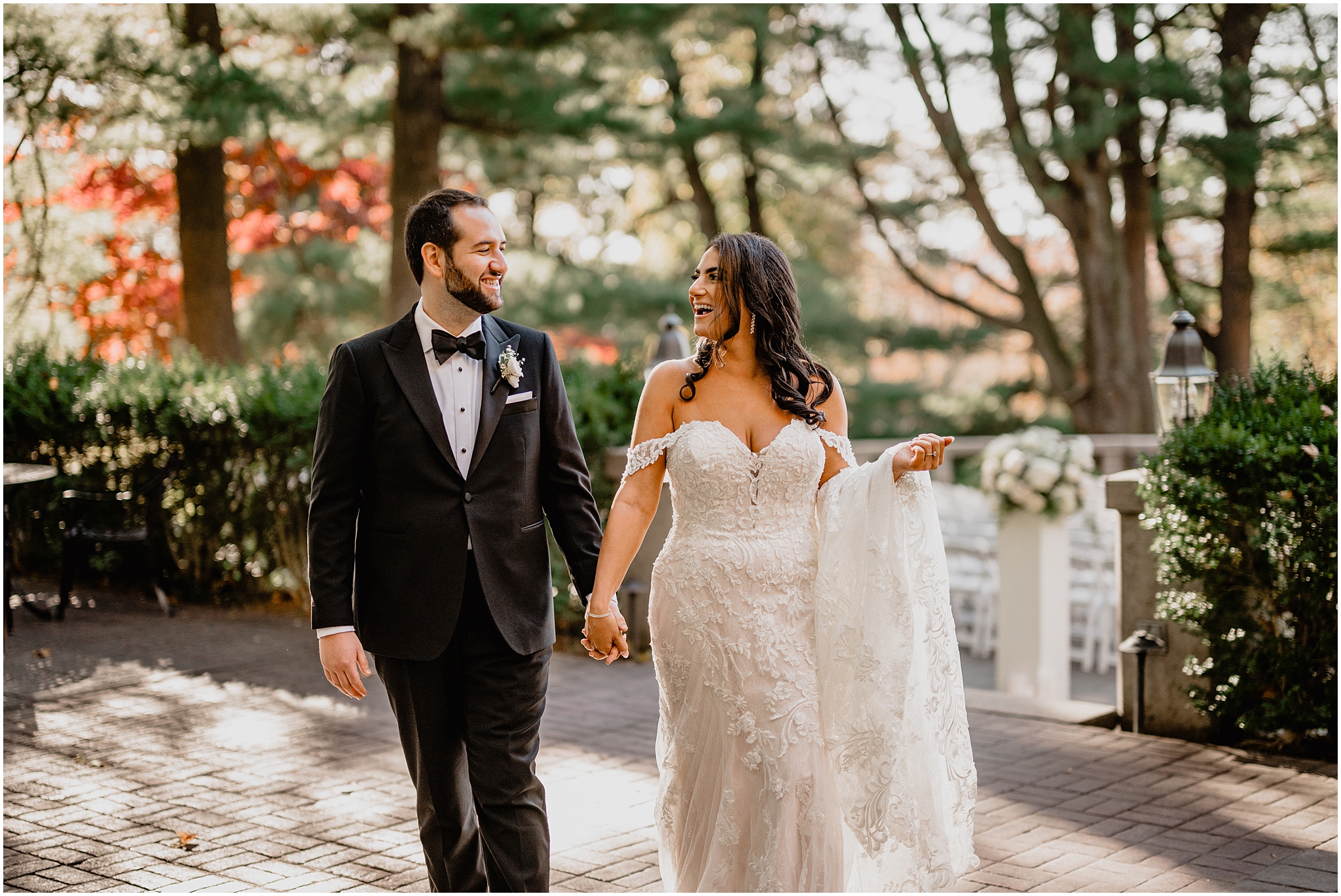 bride and groom hold hands walking on brick patio behind Tappan Hill Mansion