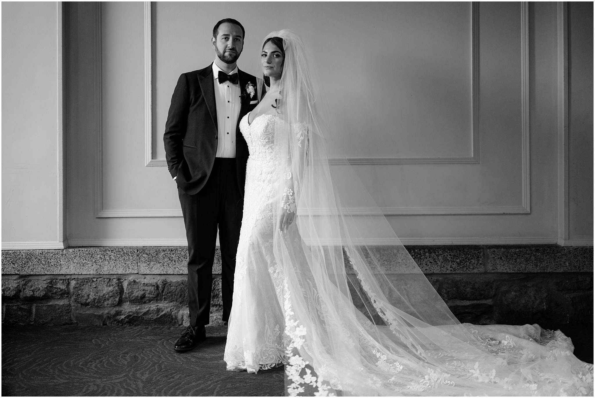 bride and groom stand in front of white wall at Tappan Hill Mansion