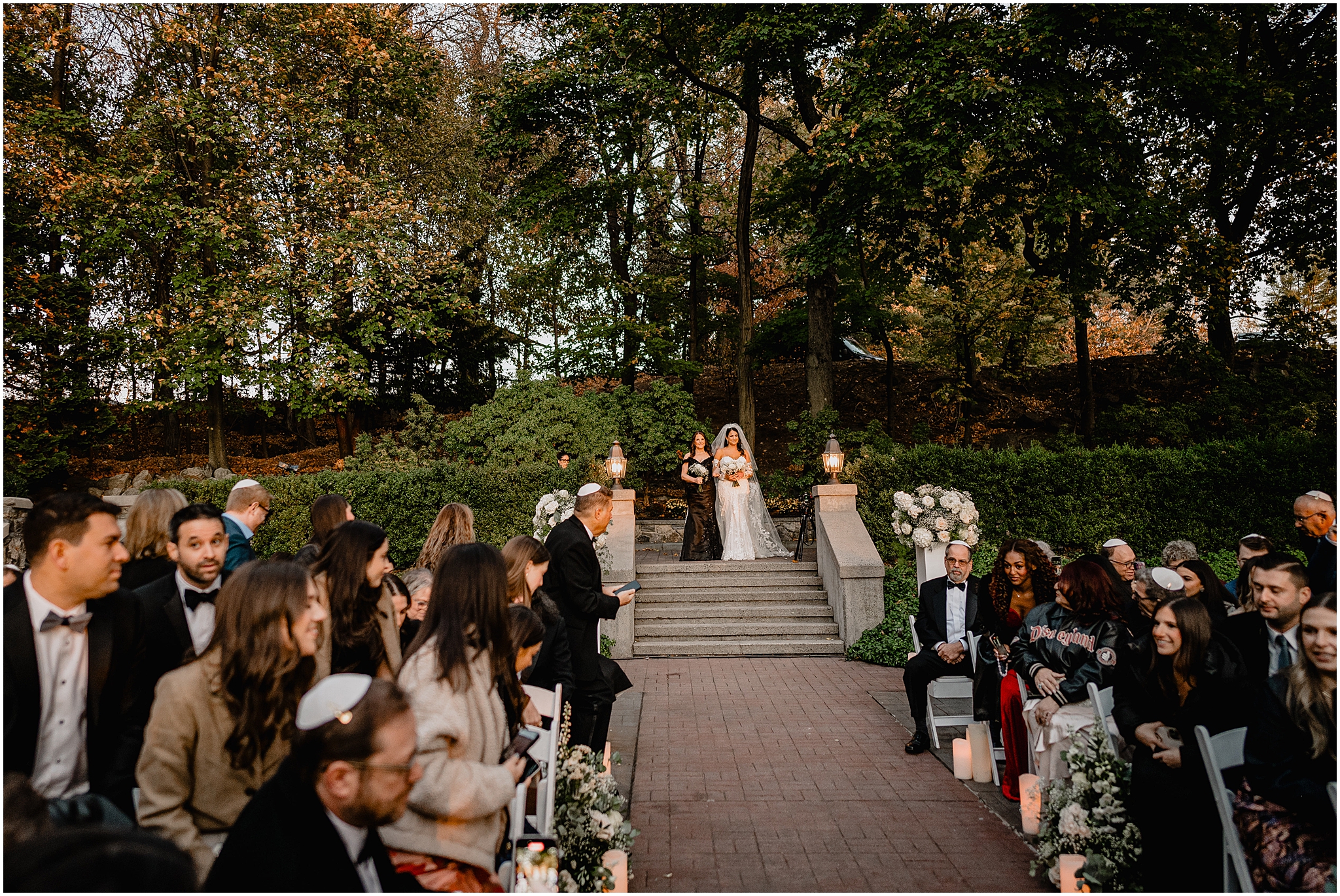 bride and mother enter Jewish wedding ceremony on the patio at Tappan Hill Mansion