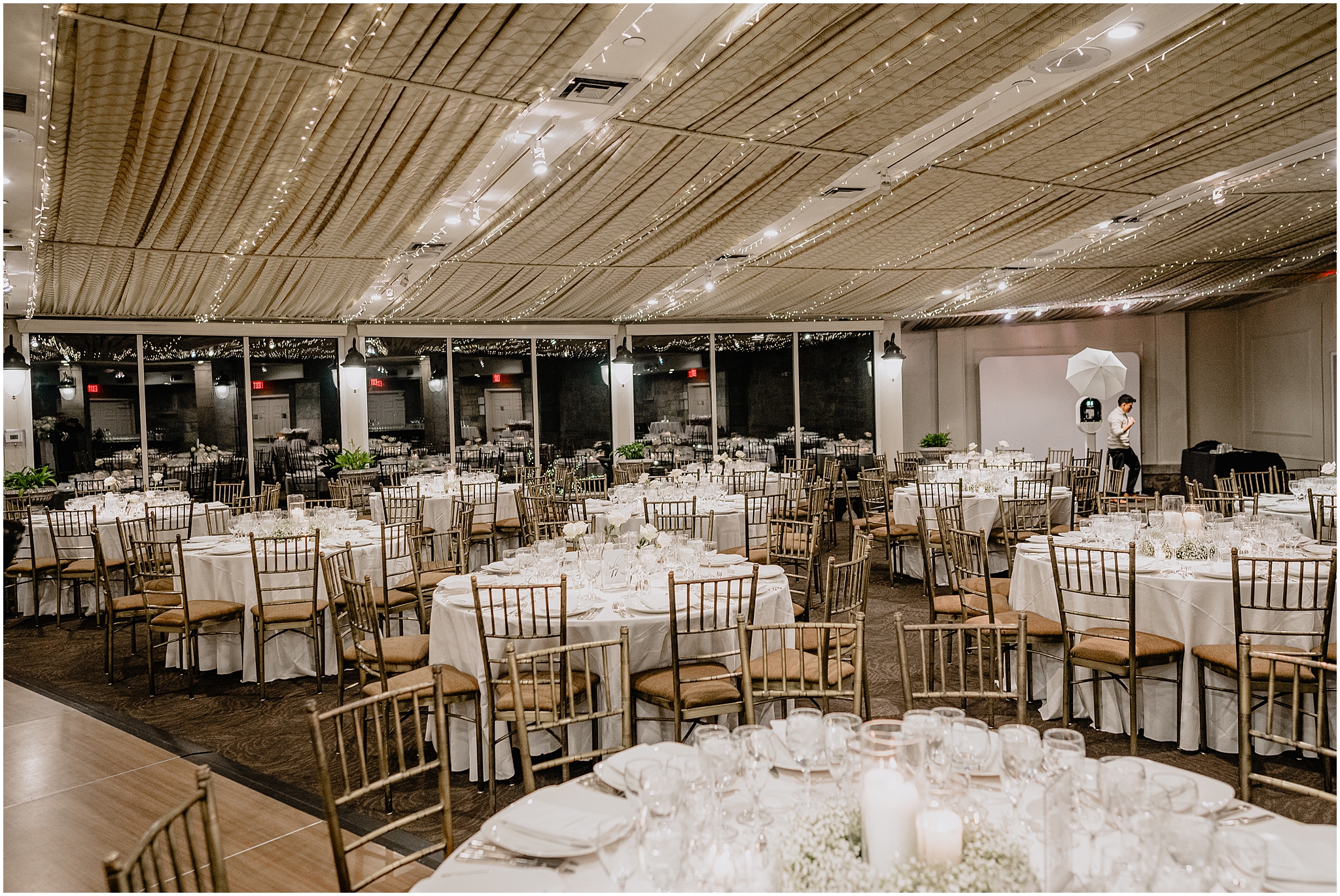 Tarrytown NY wedding reception with gold chivari chairs and baby's breath centerpieces with candles 
