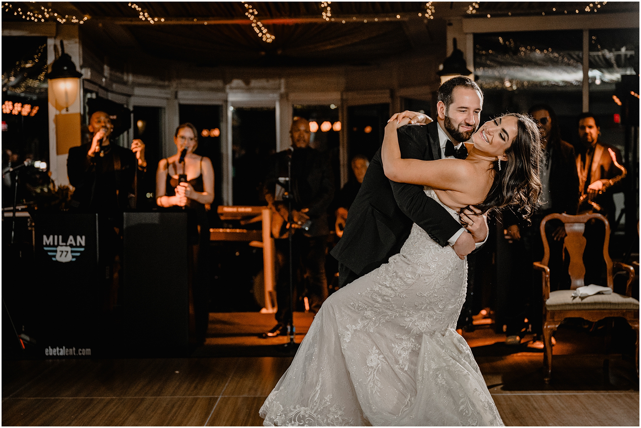 groom starts to dip bride during Tarrytown NY wedding reception while live band sings