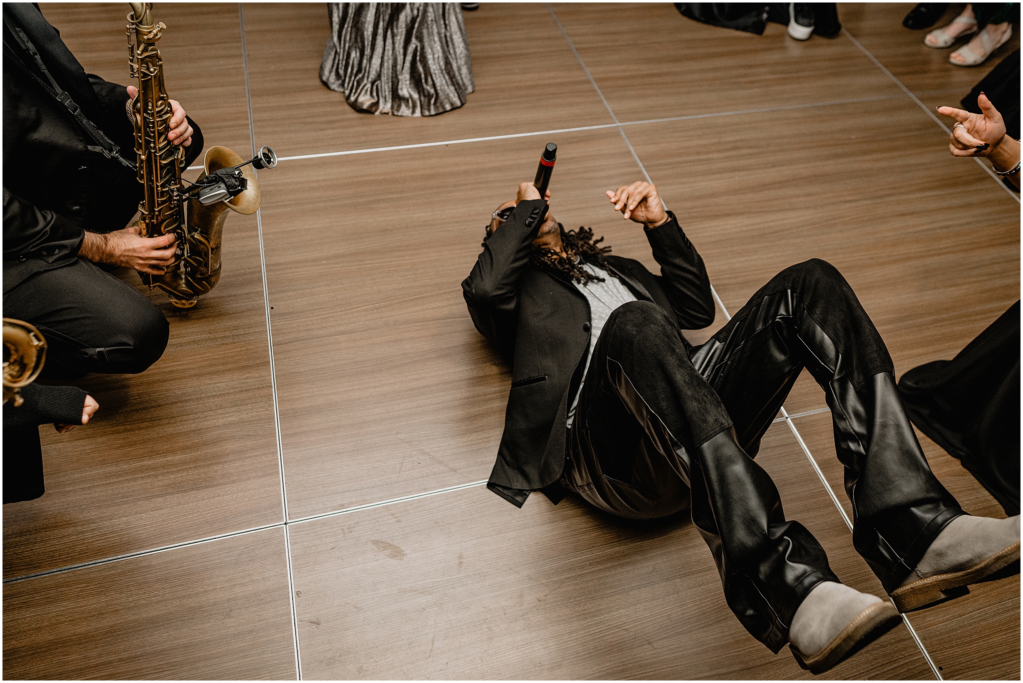singer lays on his back performing into microphone in the ballroom at Tappan Hill Mansion