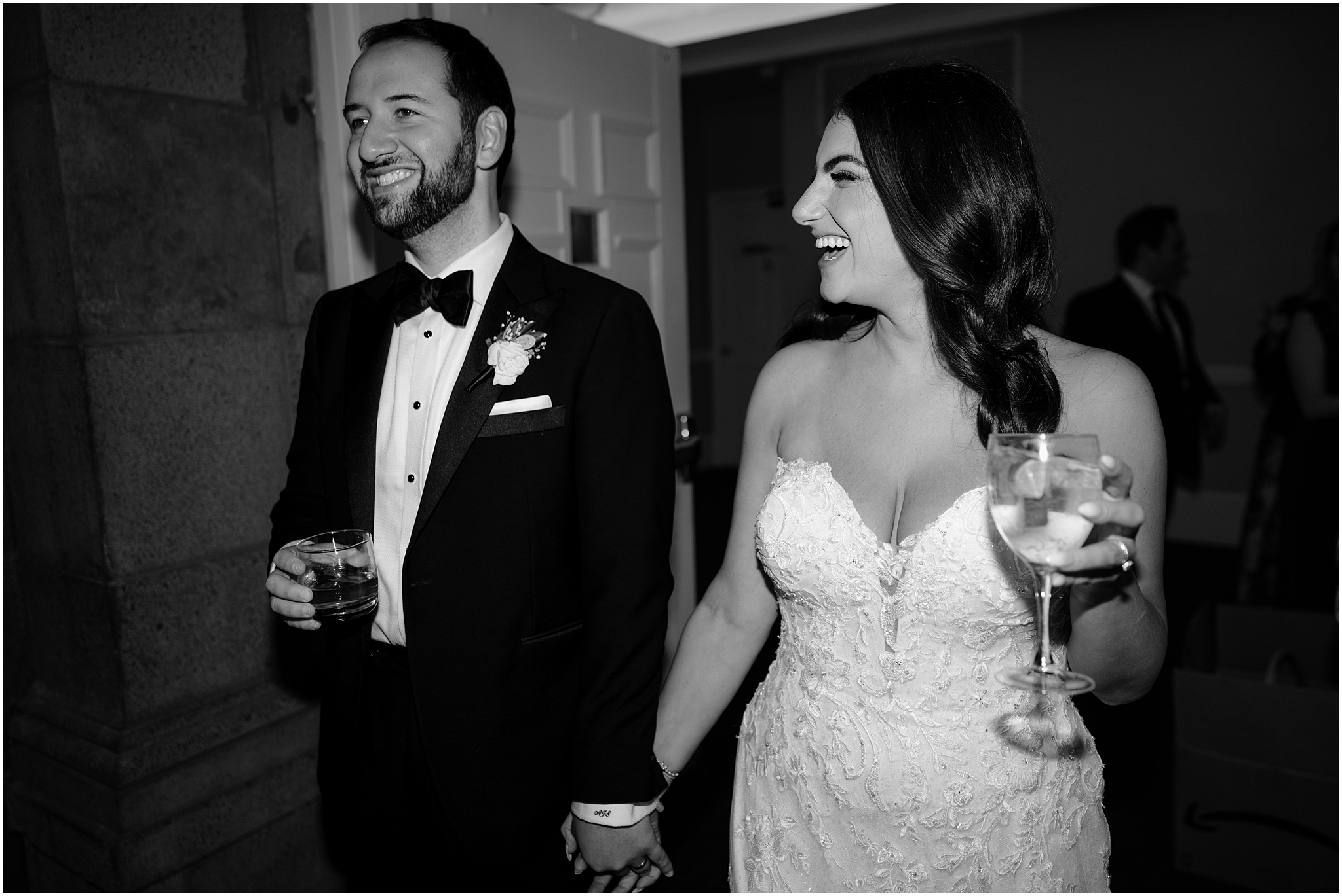 newlyweds hold hands and carry drinks through Tarrrytown NY wedding reception