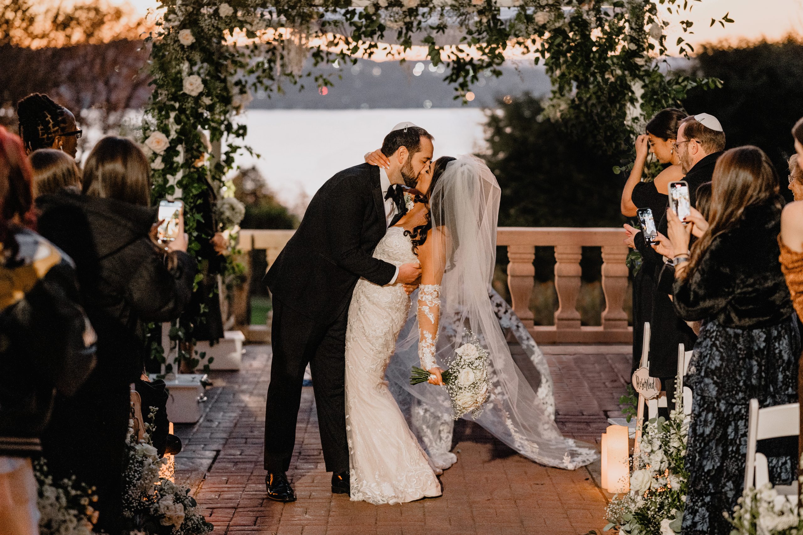 bride and groom kiss under canopy during Jewish wedding ceremony on the patio at Tappan Hill Mansion