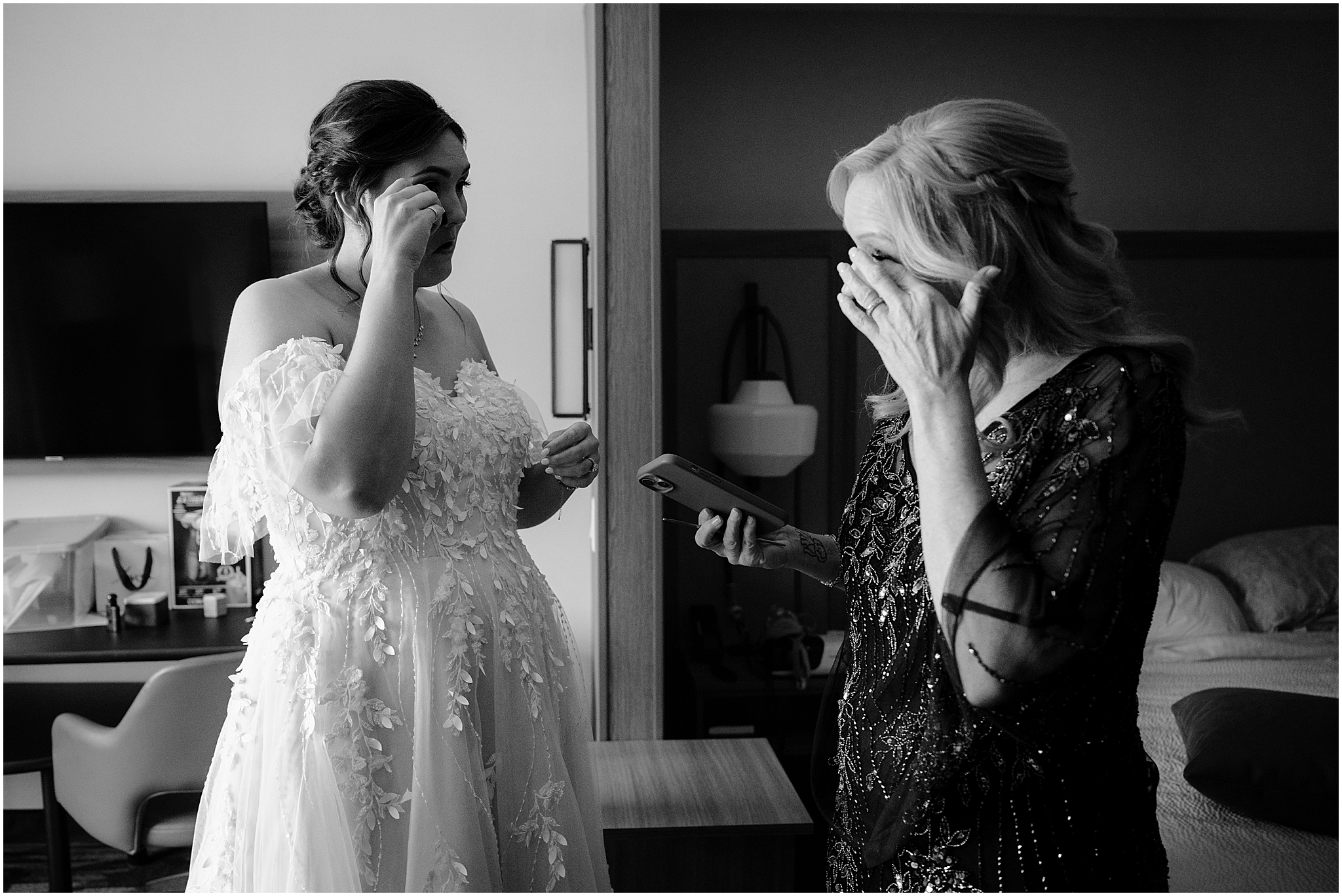 woman wipes away tears during prep for New Jersey wedding day in hotel 