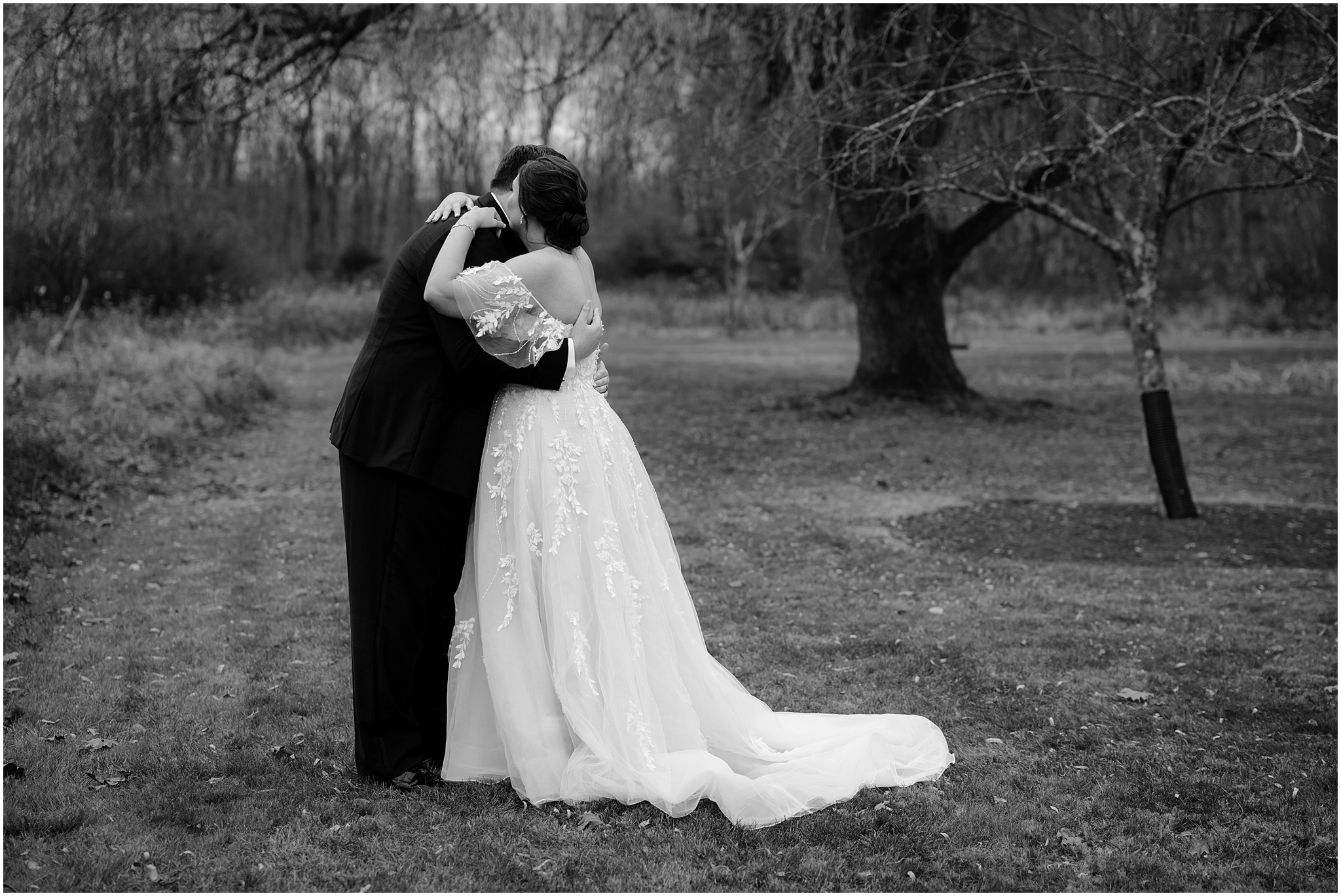 black and white photo of bride and groom hugging in field at the Perona Farms Reserve