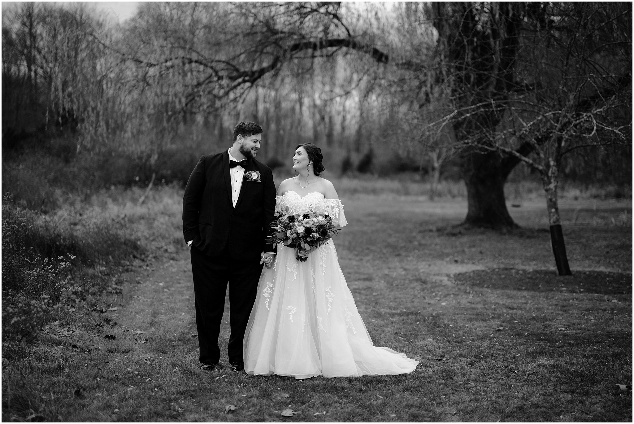 bride and groom hold hands standing in field during fall wedding portraits at the Perona Farms Reserve