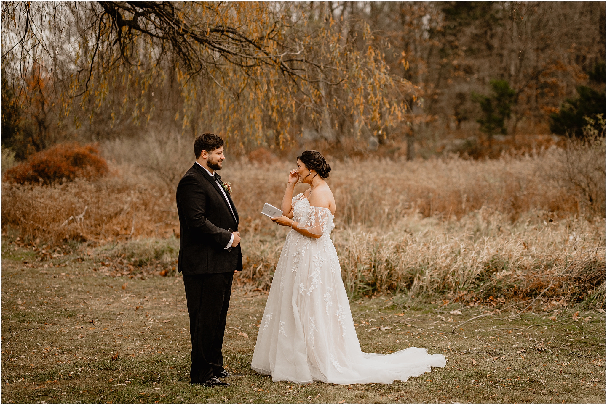 bride cries reading vow booklet during first look in field at the Perona Farms Reserve