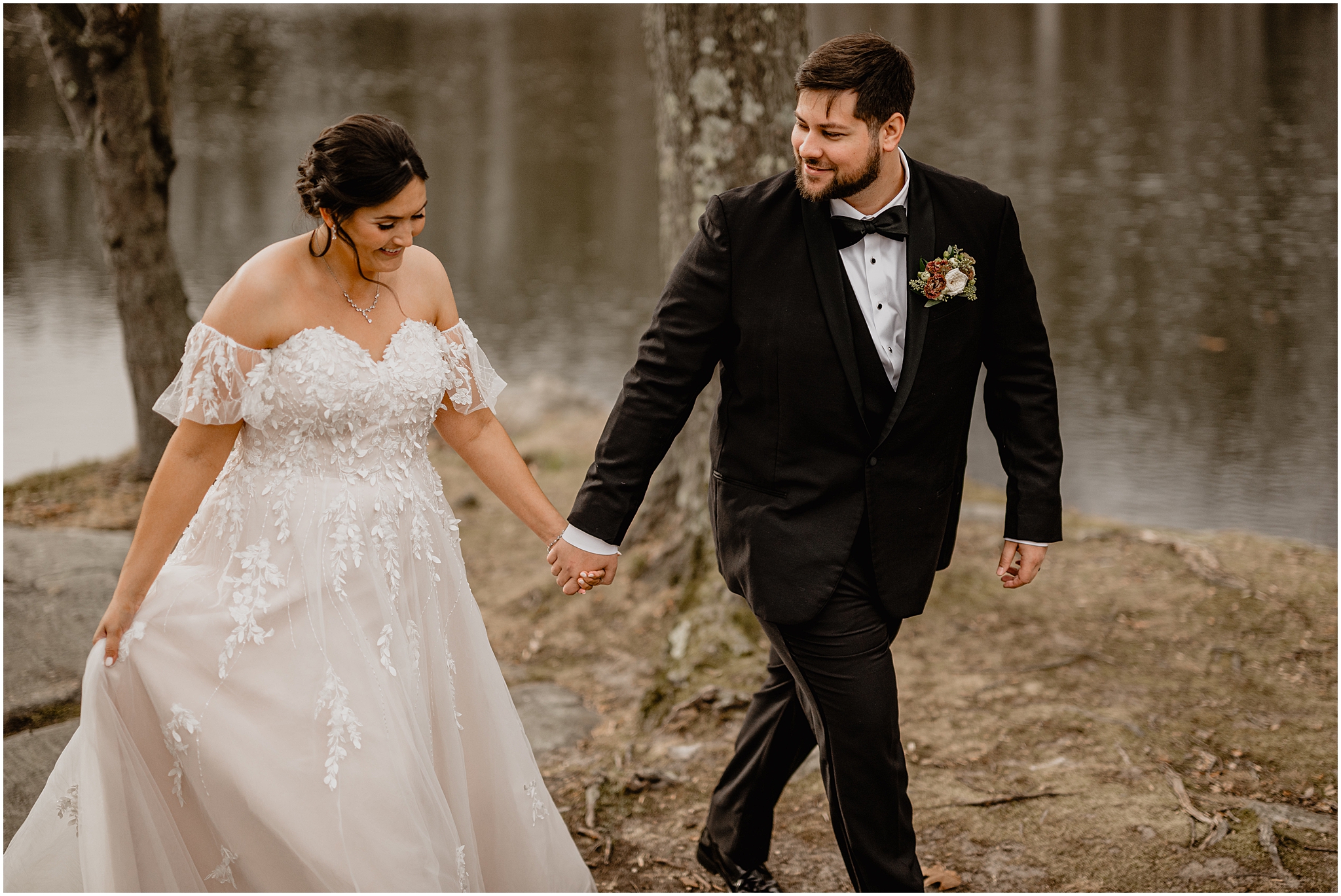 bride and groom hold hands walking through woods at the Perona Farms Reserve by pond