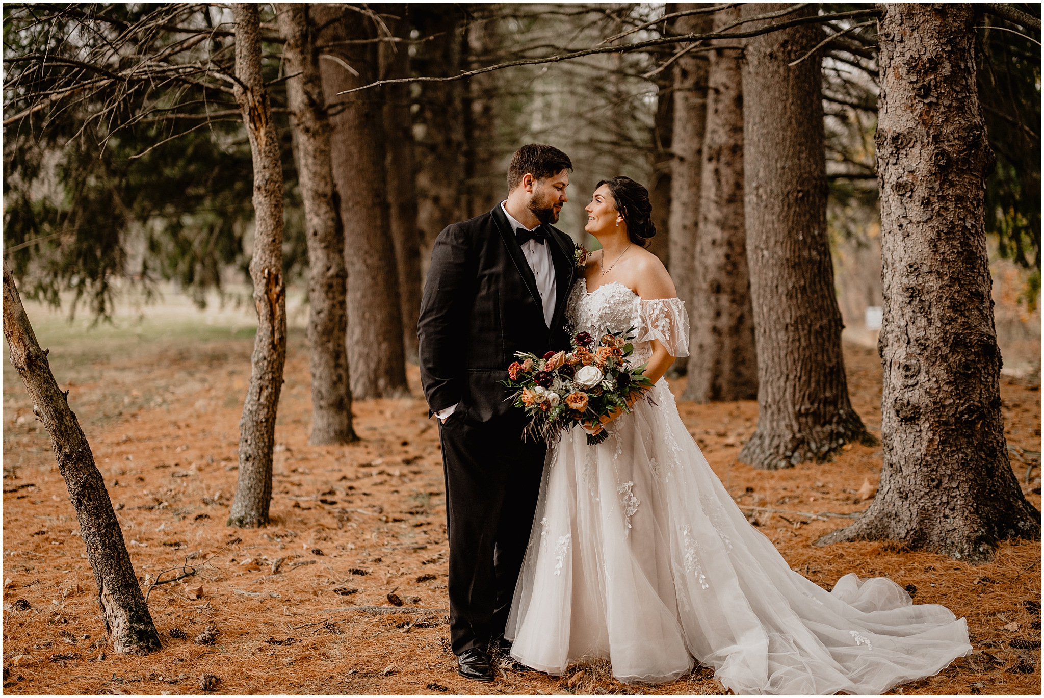 bride and groom hug between trees during fall wedding day at the Perona Farms Reserve