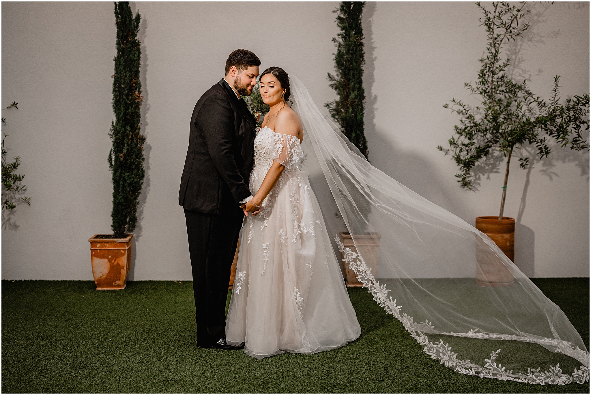 groom looks at bride holding her hands during wedding portraits at Perona Farms Reserve
