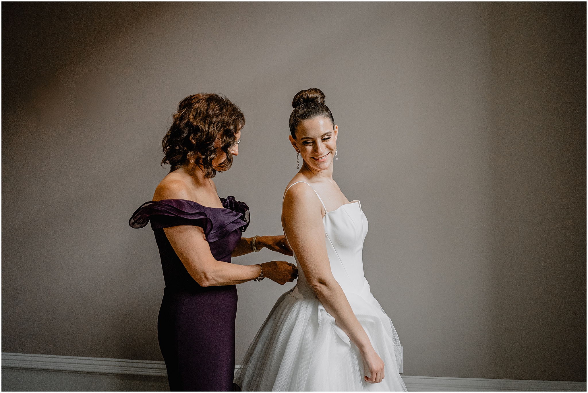 mother helps bride into wedding dress in Philly PA hotel room