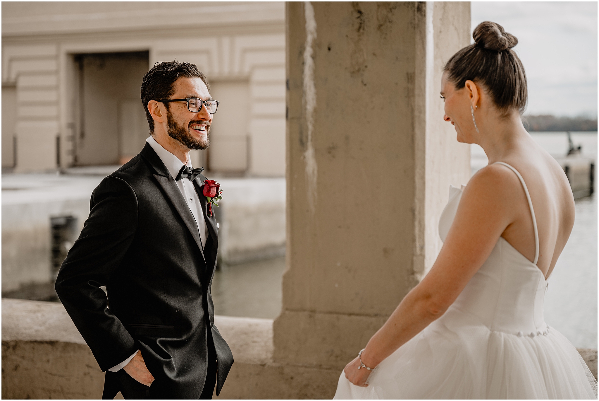 groom turns to look at bride during first look at Penn Landing along the Delaware River