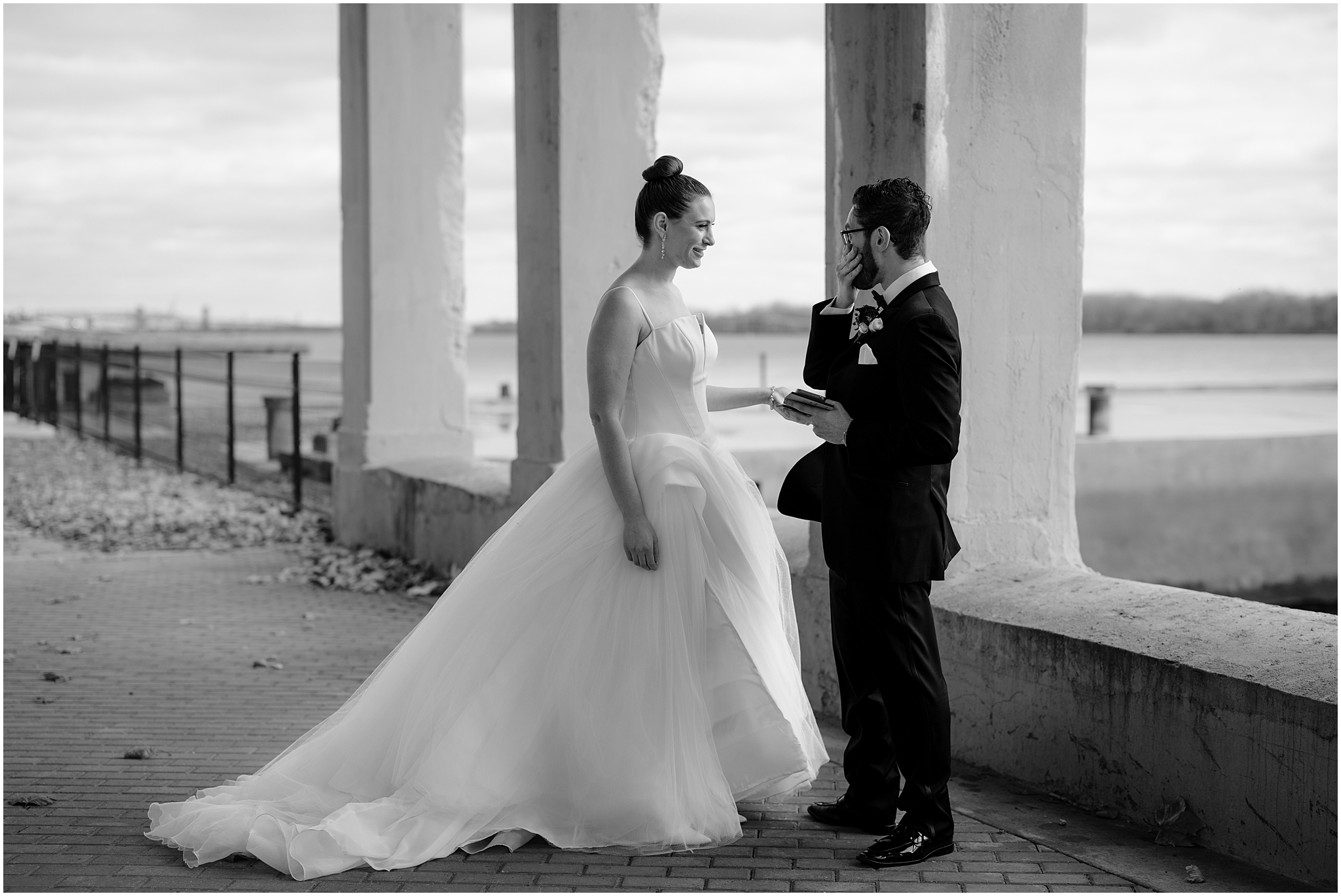 newlyweds talk under bridge at Penn Landing along the Delaware River