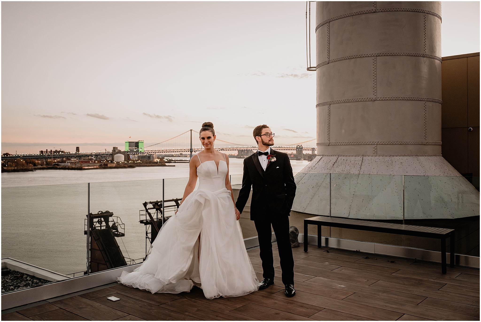 newlyweds hold hands in front of glass wall around patio at Cescaphe's Switch House in Philly PA