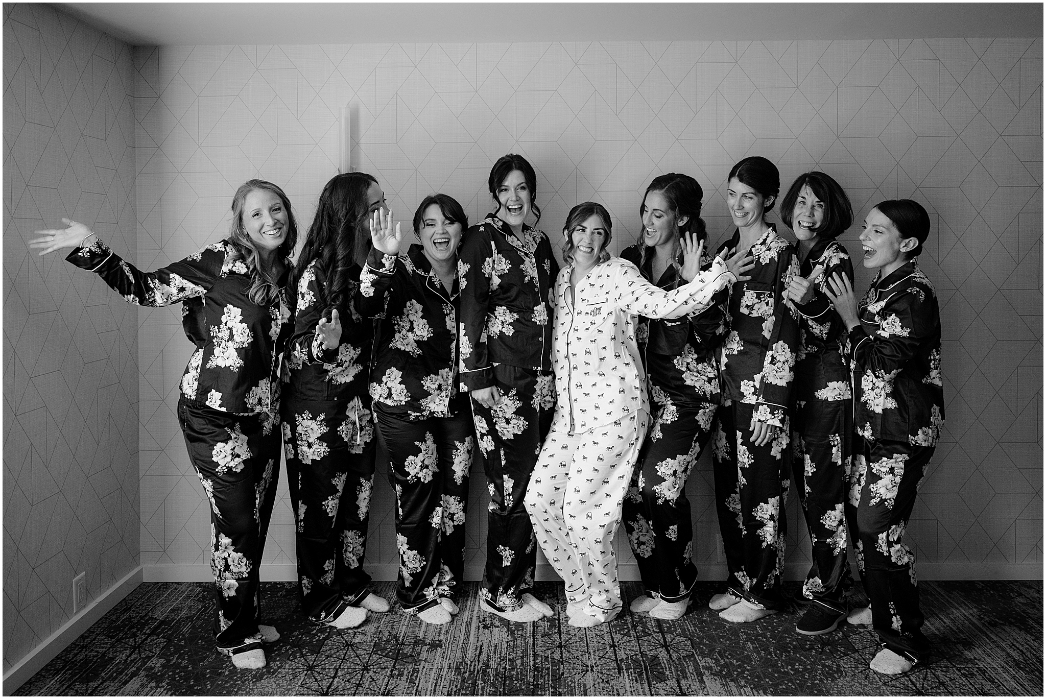bride poses with bridesmaids in matching floral pajamas in Hudson Valley hotel