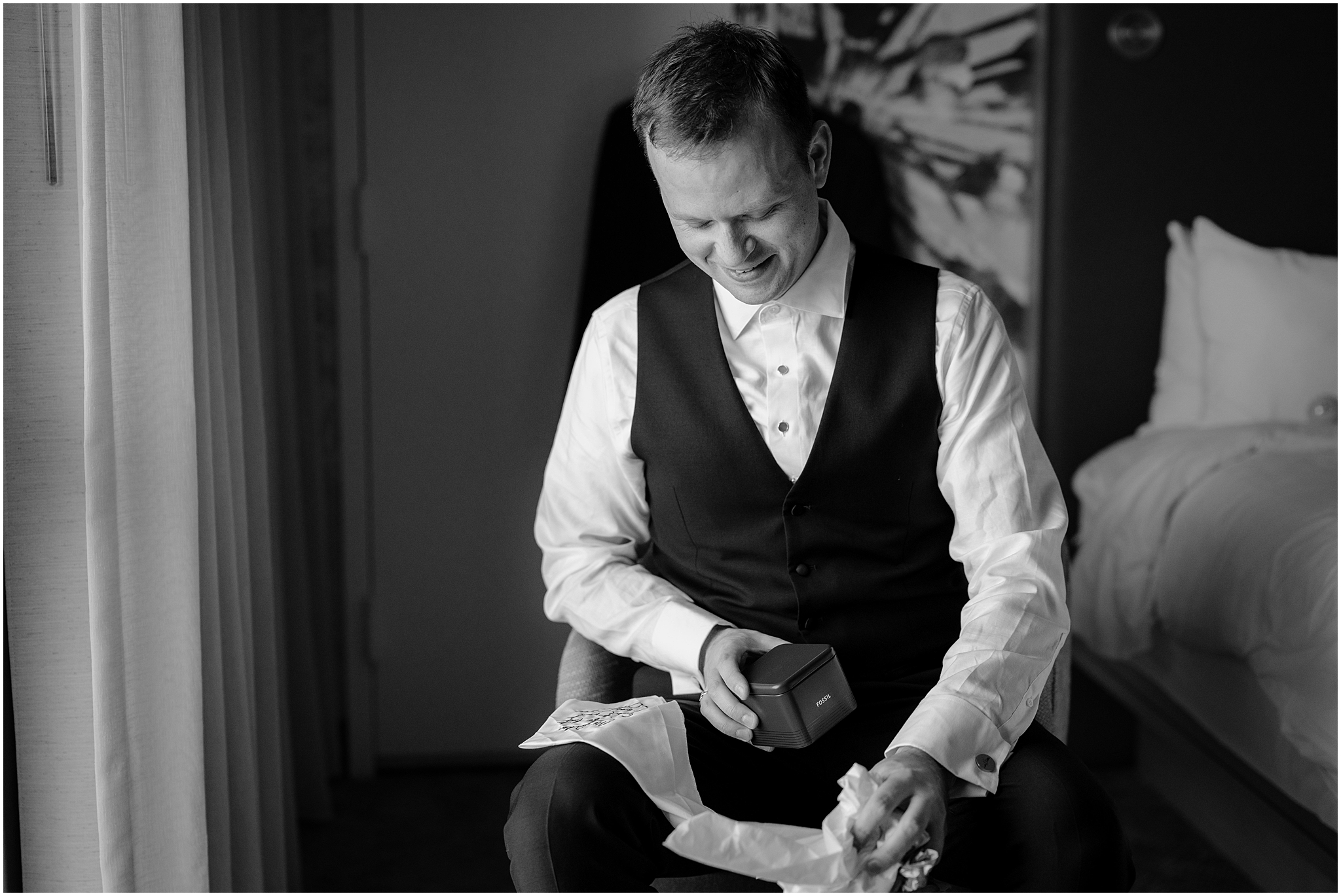 groom opens gift in Hudson Valley hotel during wedding day prep