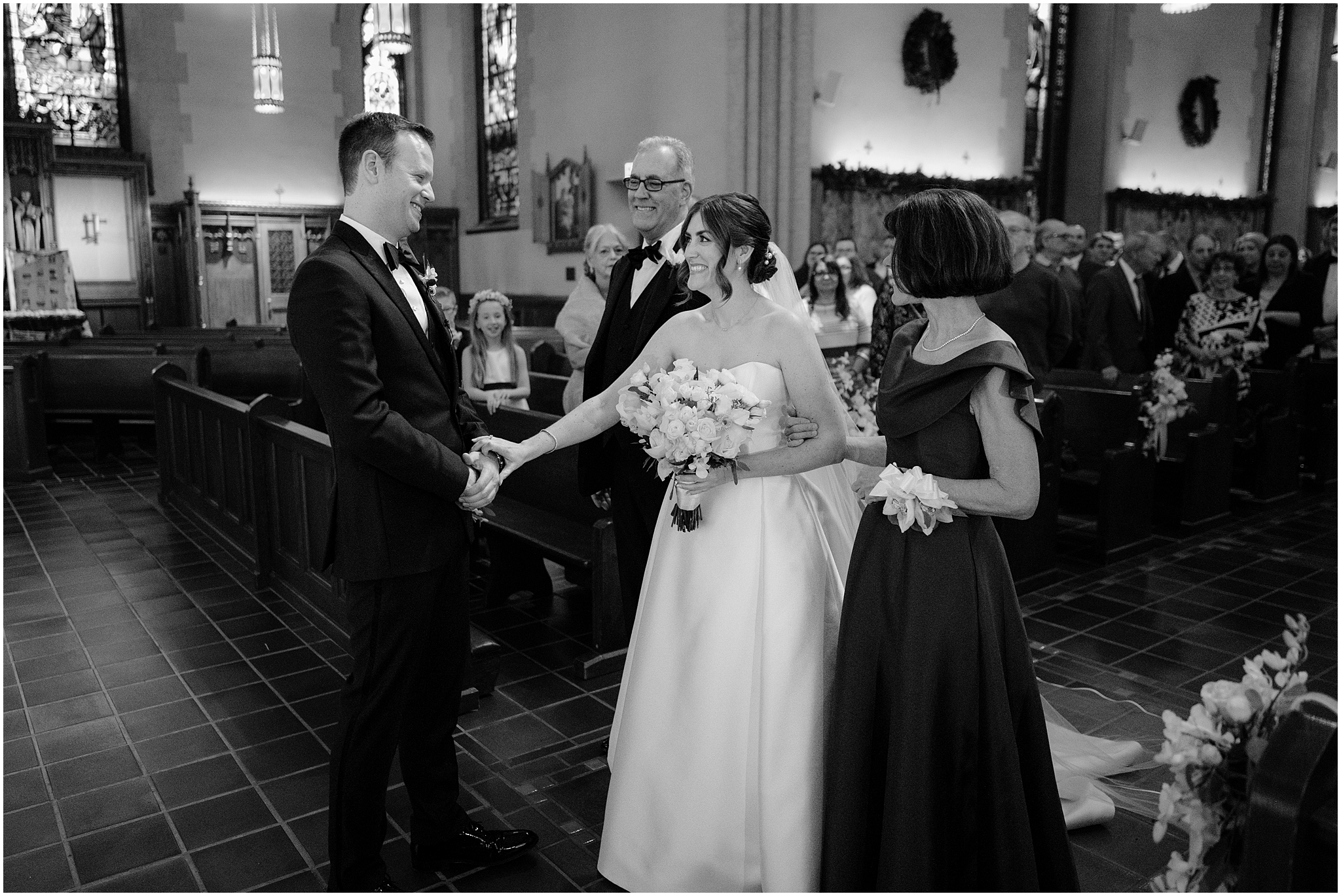 bride reaches to hold groom's hand during ceremony inside New York church