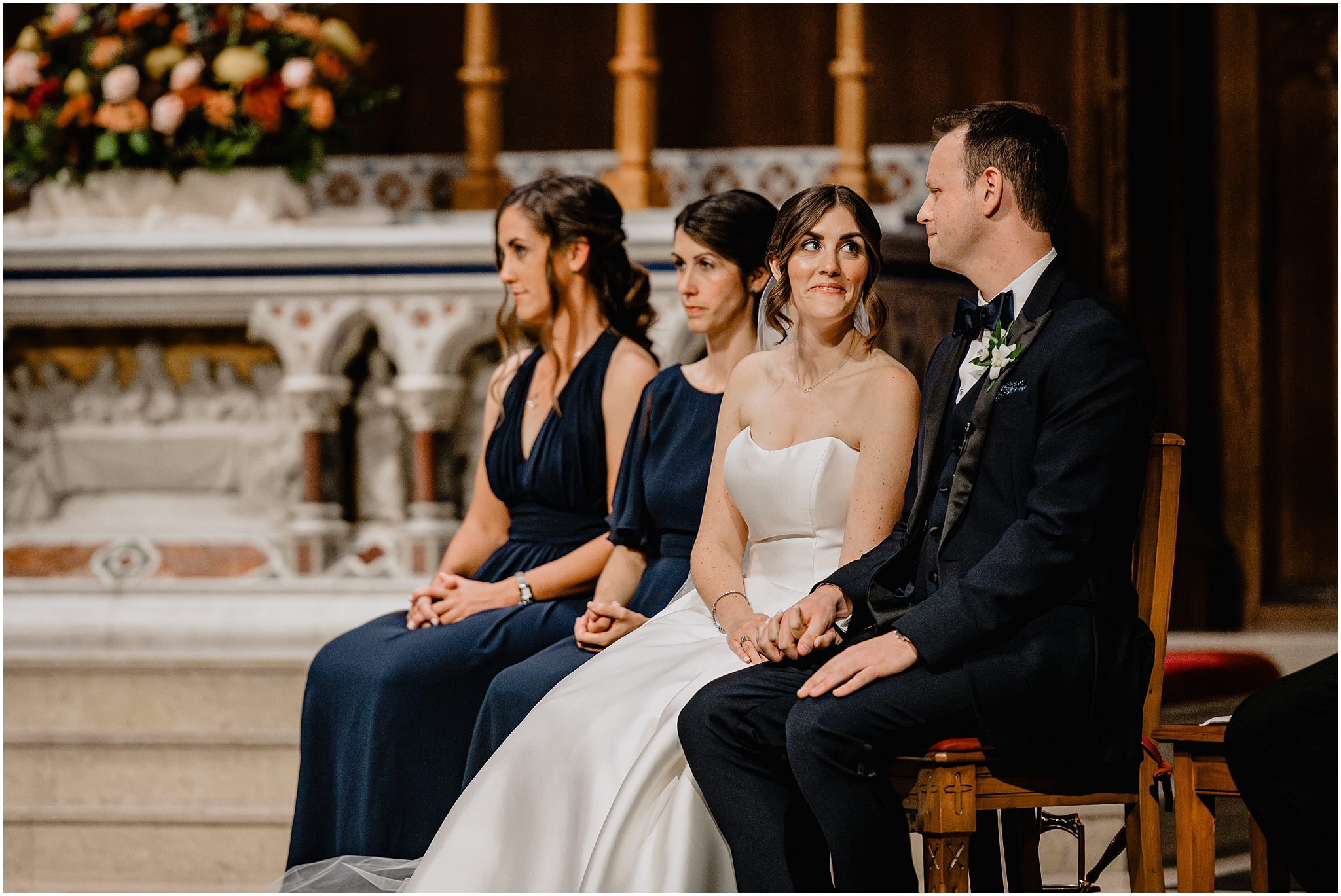 bride looks at groom during traditional Catholic wedding ceremony inside New York Church