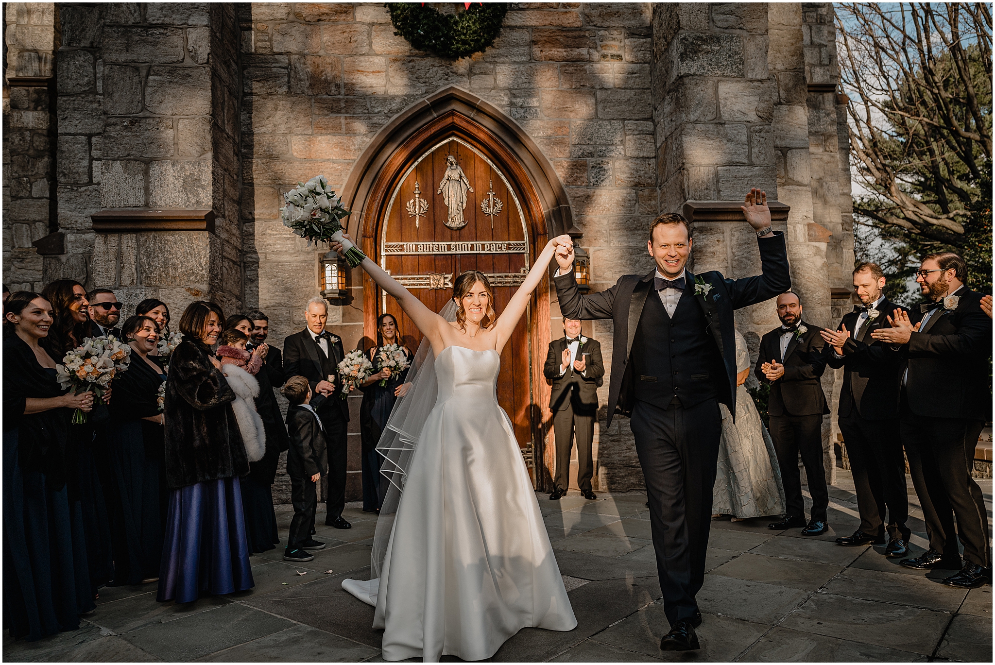 newlyweds cheer leaving stone church with wedding guests around them in NYC