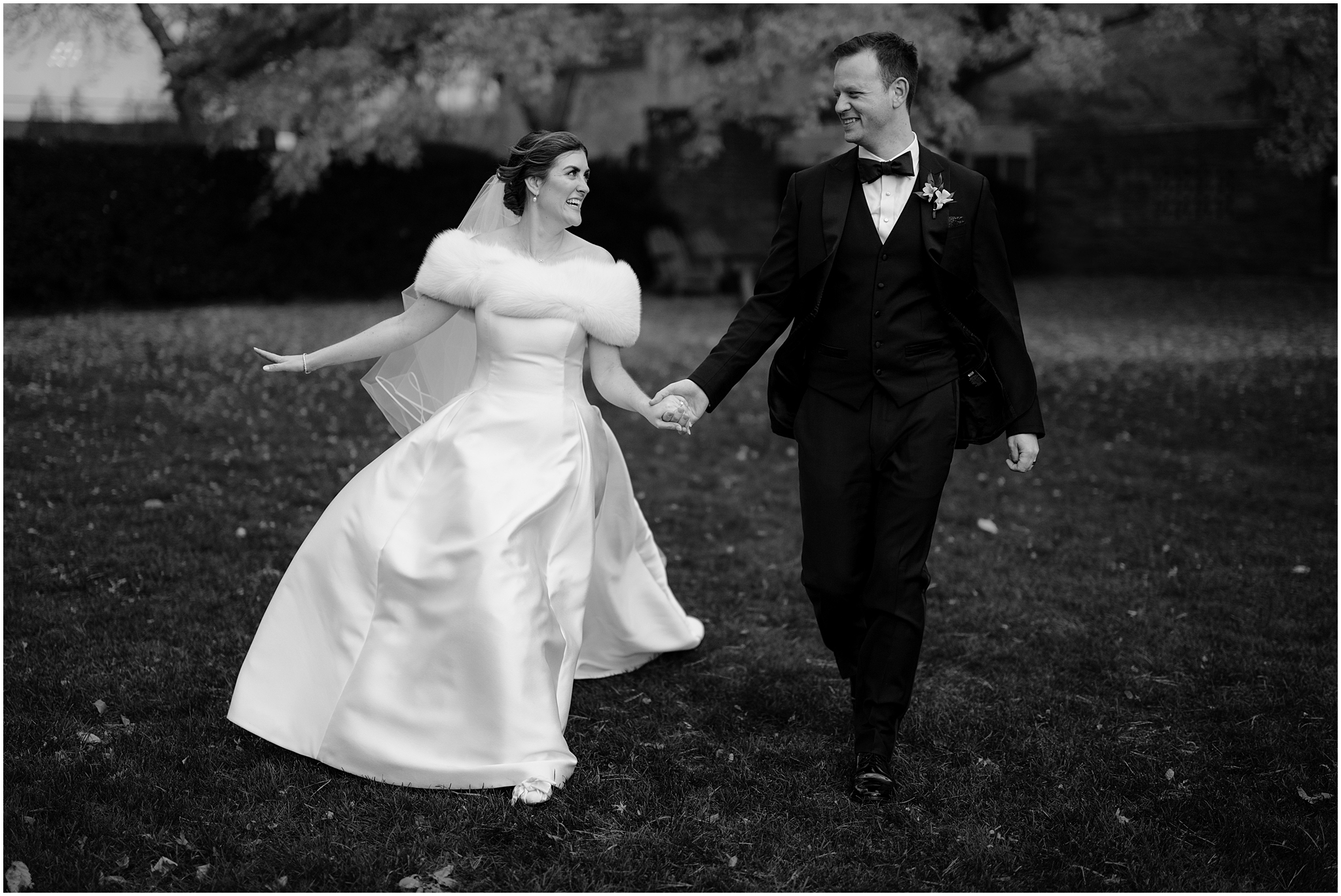 newlyweds hold hands running across the lawn in the Hudson Valley