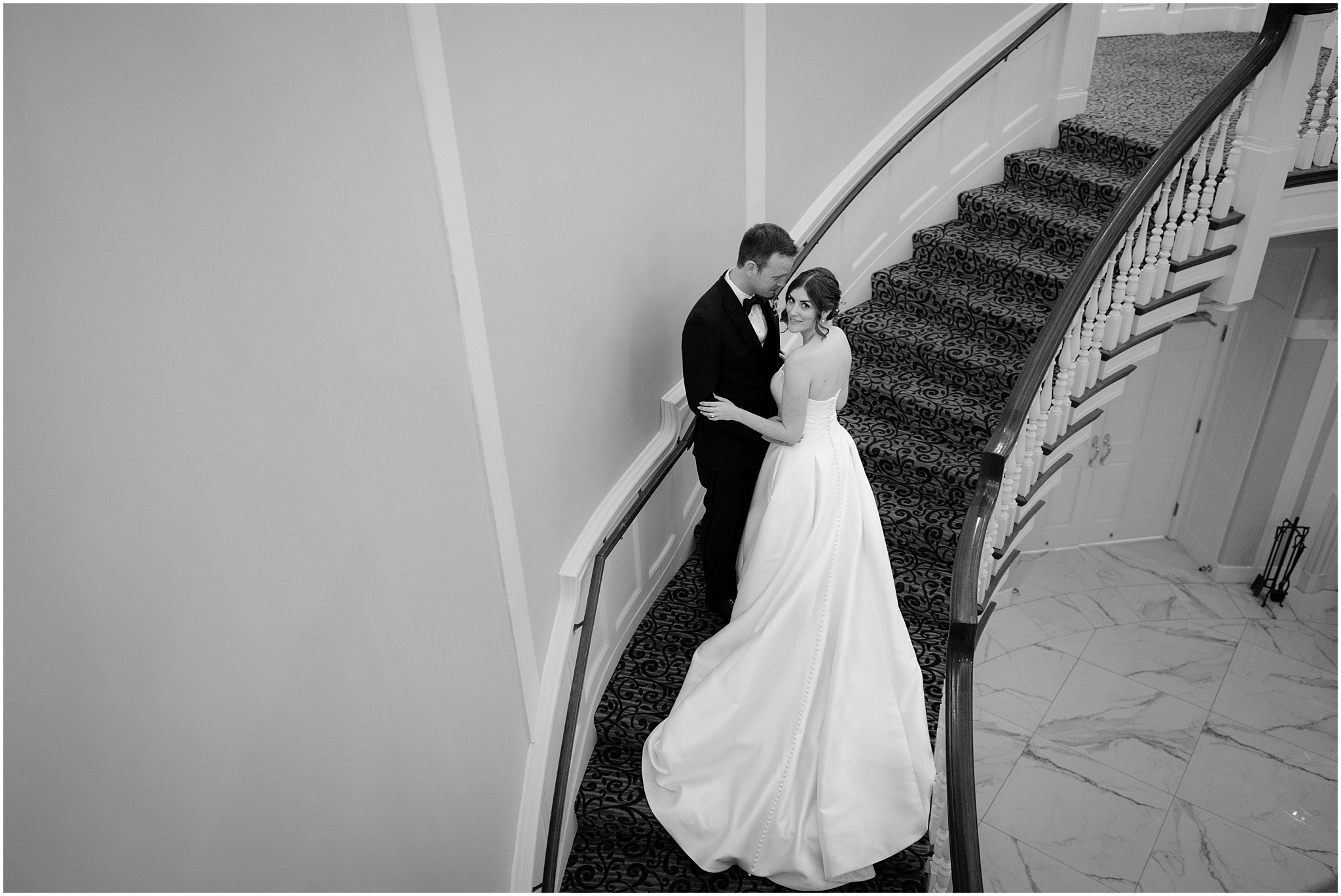 bride and groom pose on spiral staircase inside Tappan Hill Mansion