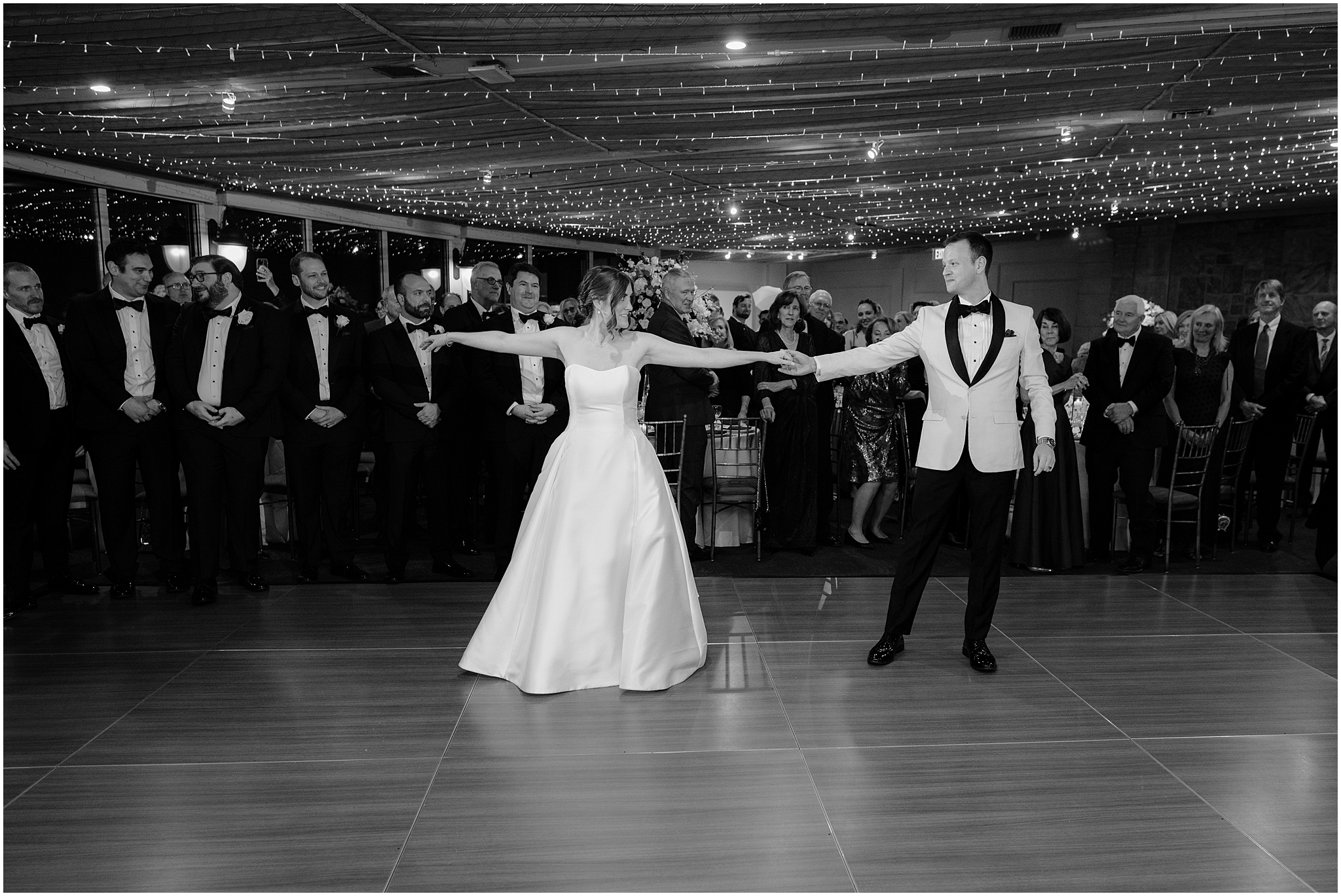 groom twirls bride out on dance floor inside Tappan Hill Mansion