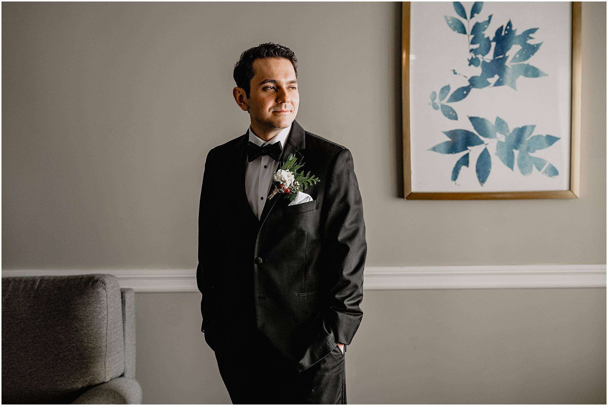 groom stands with hands in pocket of black suit during prep at the Madison Hotel in Morristown NJ