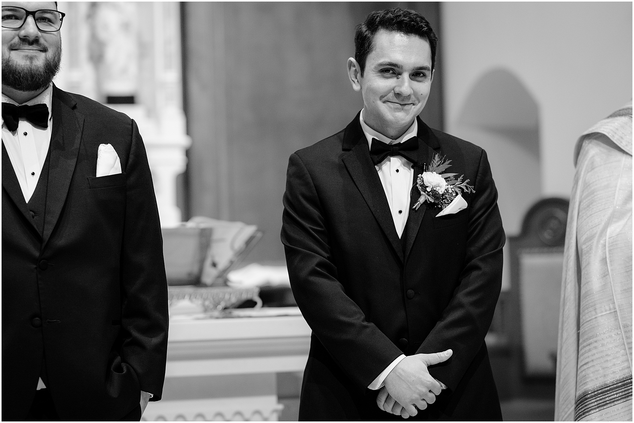 groom smiles watching aisle during wedding ceremony inside New Jersey church