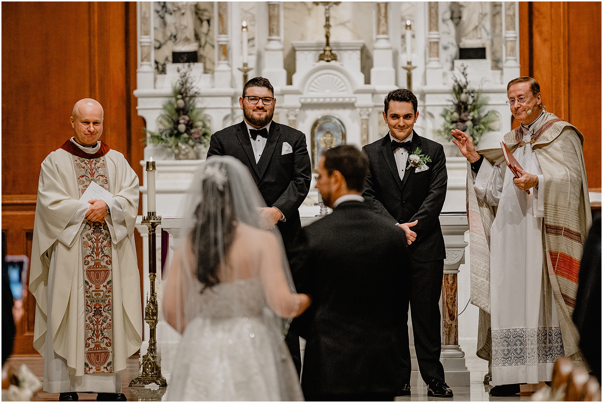 groom looks down at bride and father walking up aisle inside historic church in New Jersey