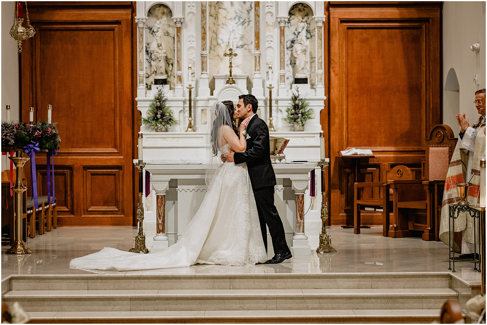 newlyweds kiss by alter inside historic church in New Jersey