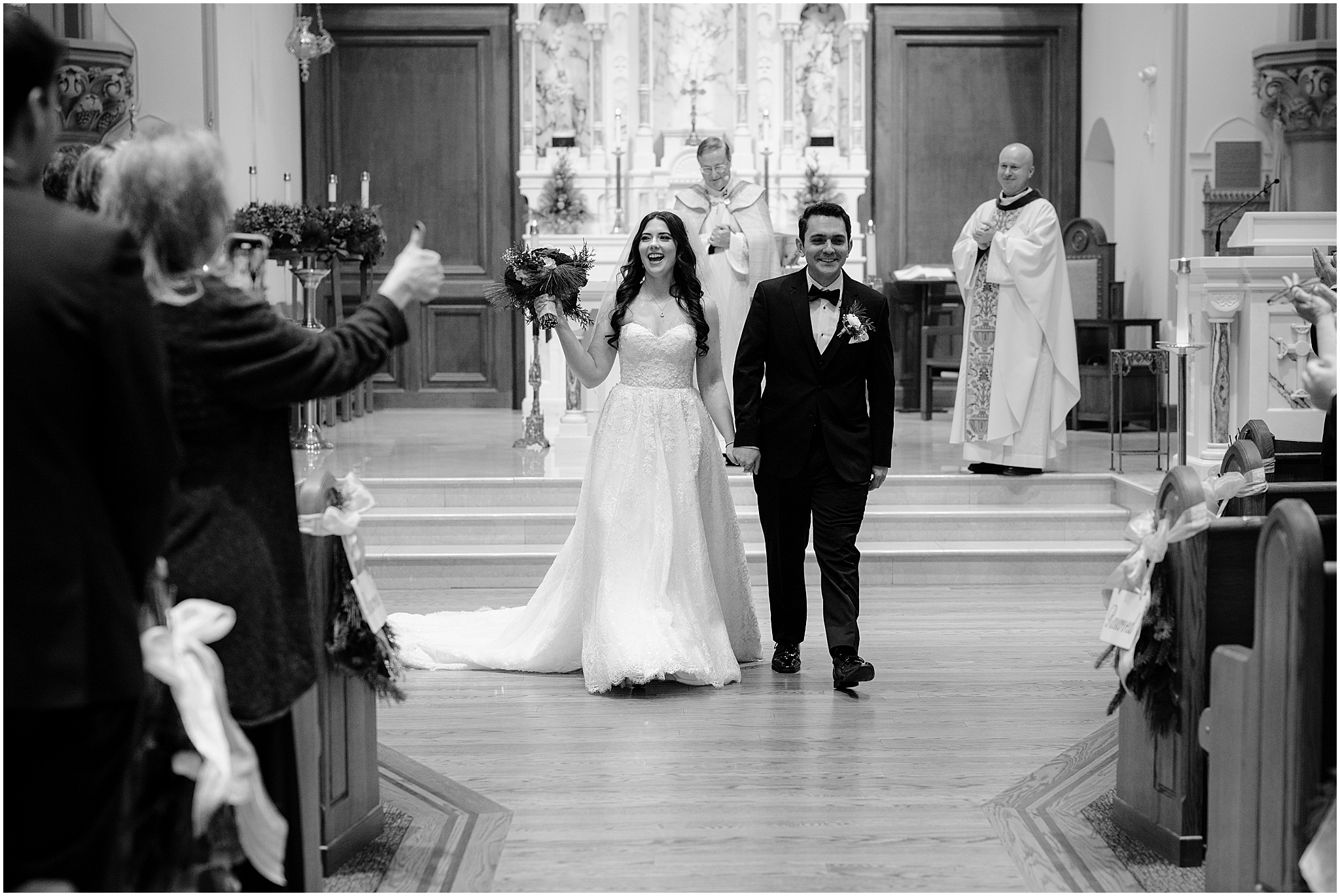 bride and groom cheer walking up aisle inside historic church in New Jersey