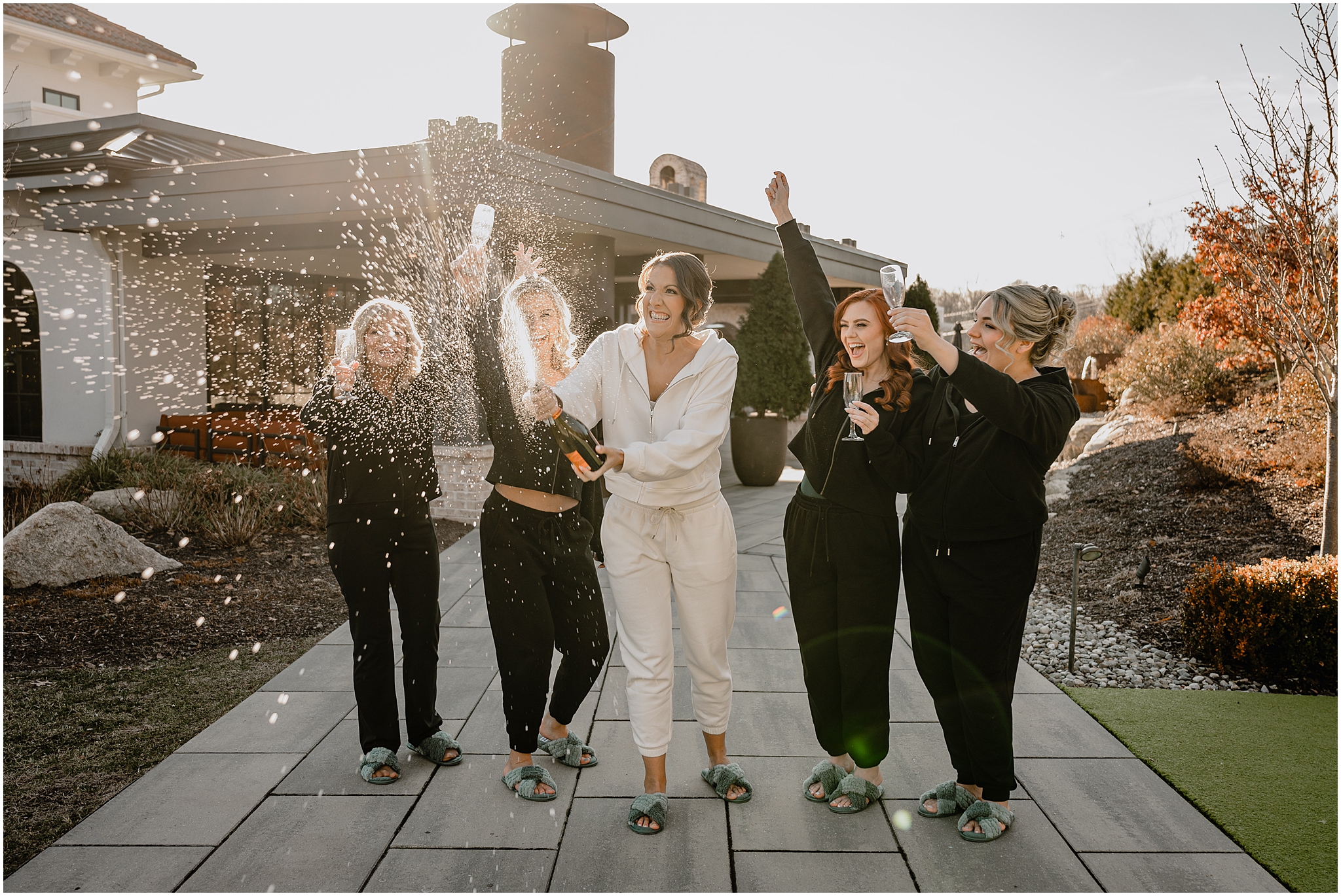 Bride with her bridesmaid drinking champagne before her winter wedding at Perona Farms Refinery.