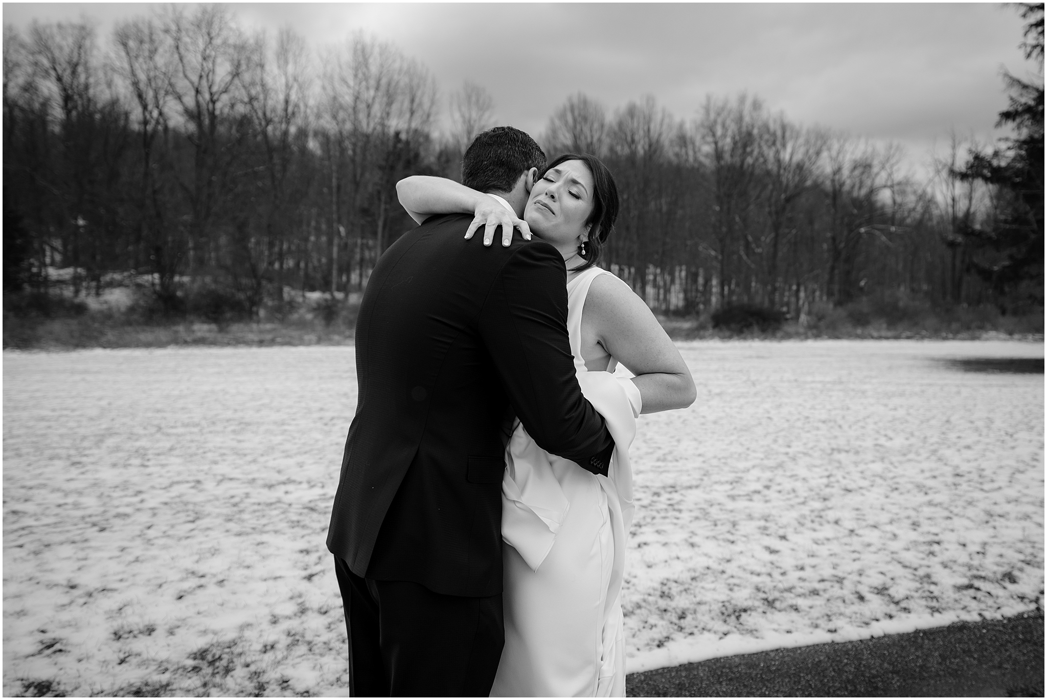 Couple hugging before their winter wedding at The Barn at Perona Farms.
