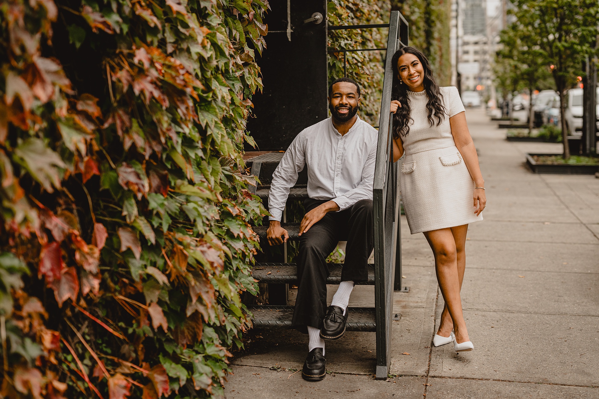 woman leans against staircase outside The Foundry with man sitting on steps