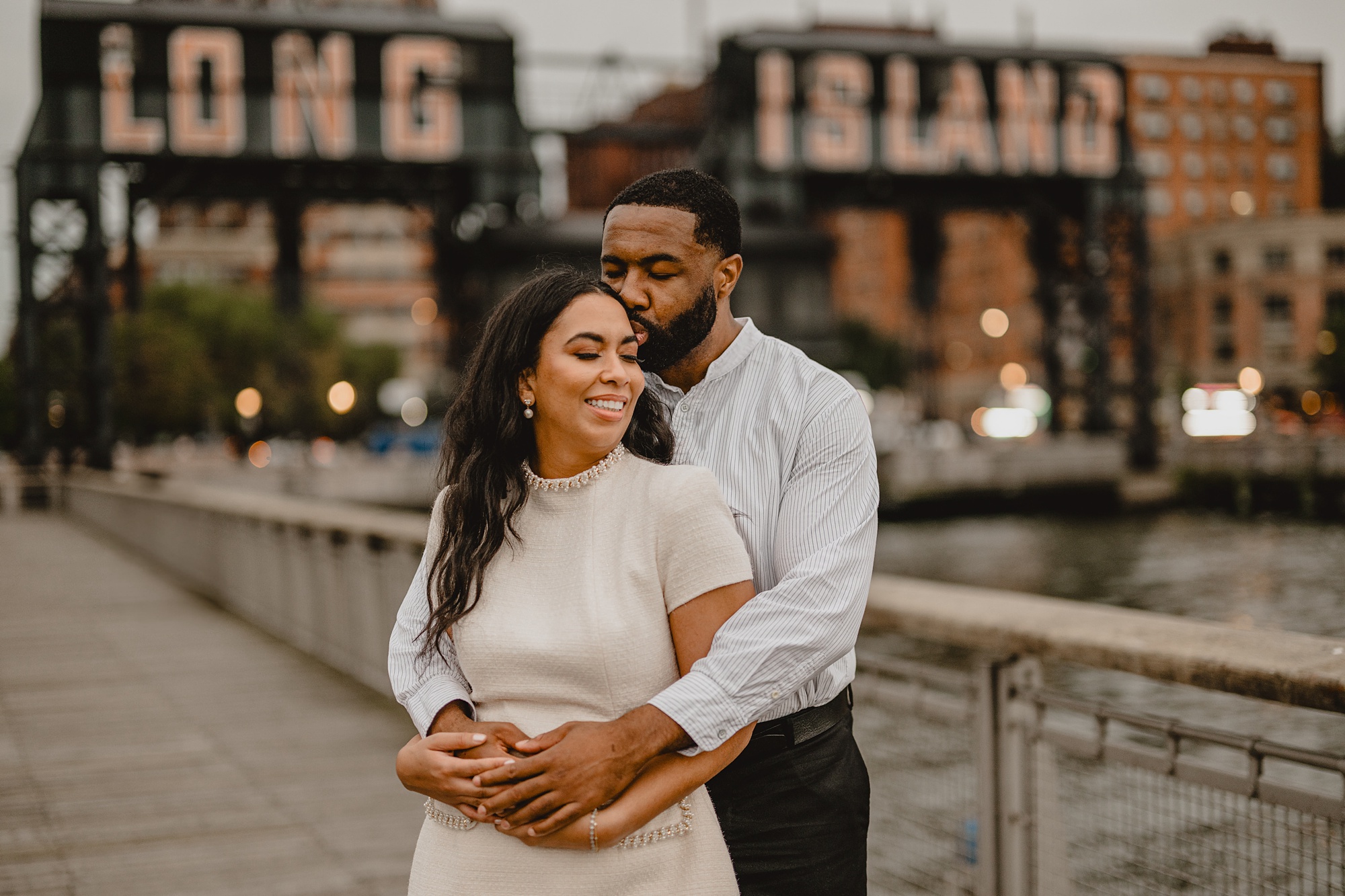 groom hugs woman from behind in front of Long Island City restaurant