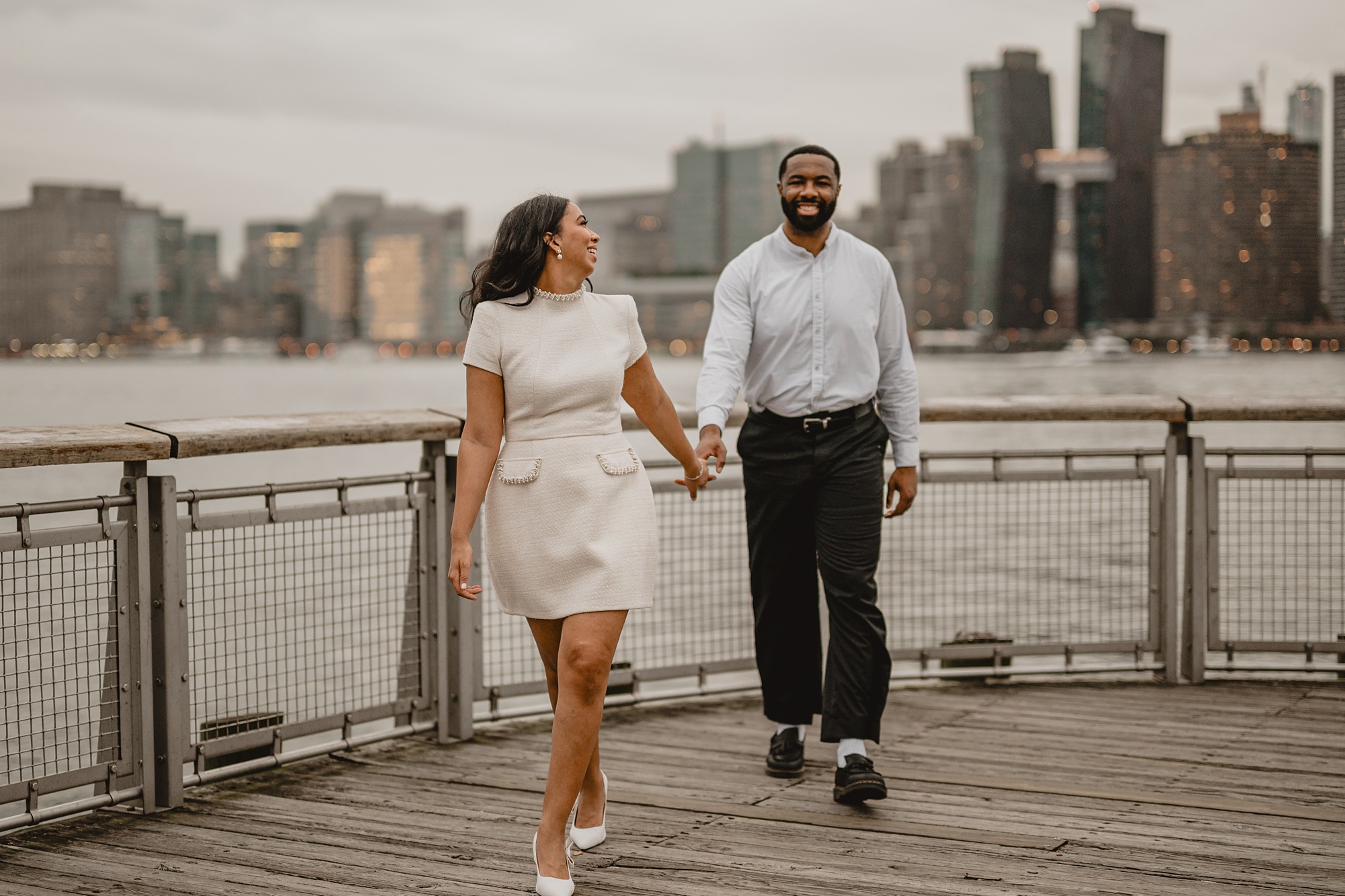 couple holds hands walking on dock at Gantry State Park Plaza