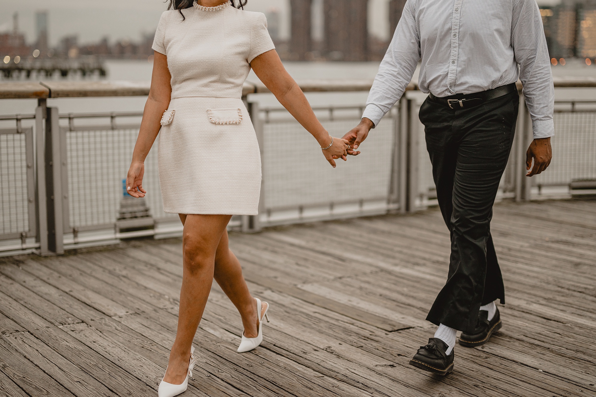 woman in ivory dress holds hands with man walking on dock at Gantry State Park Plaza