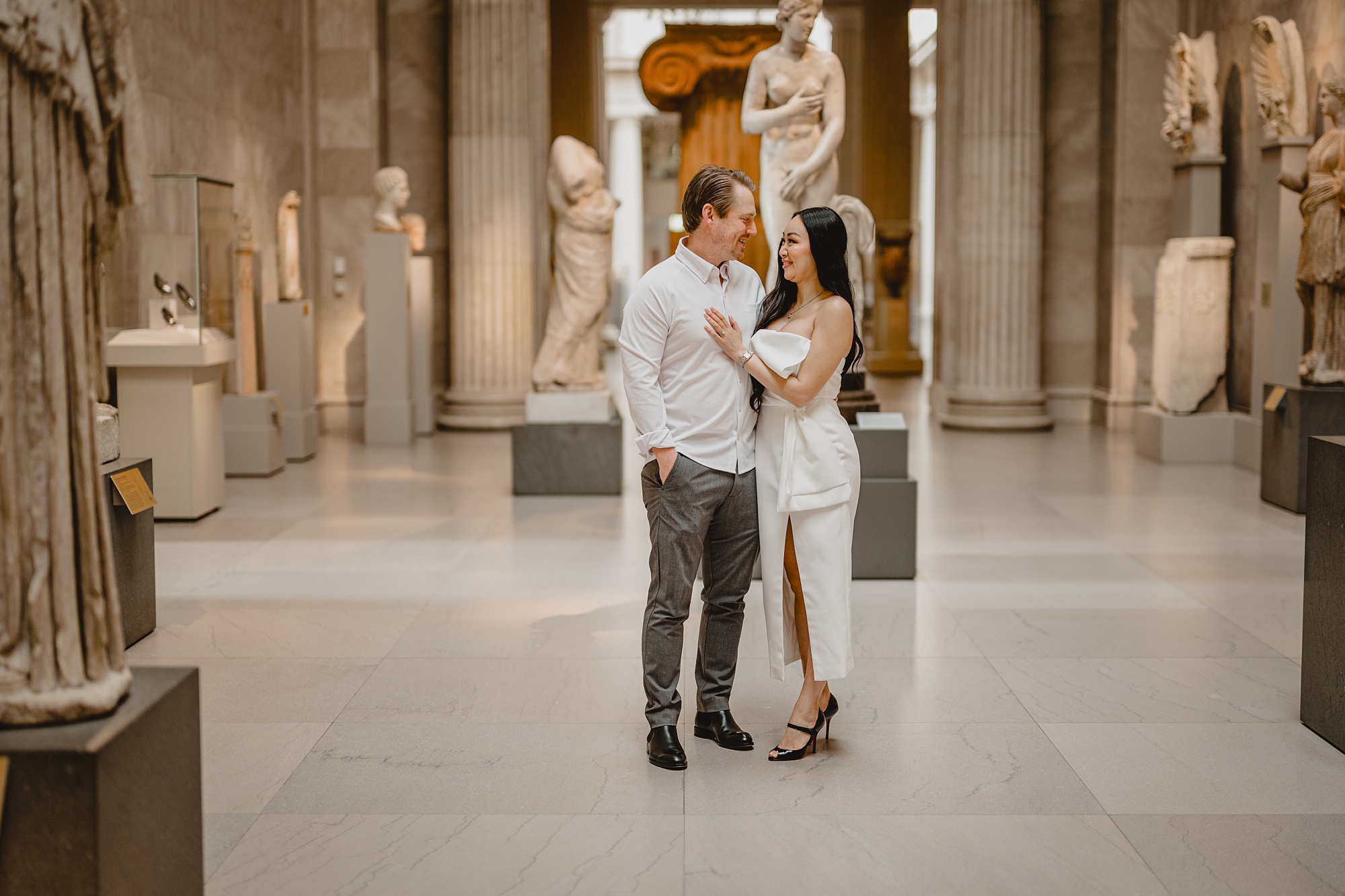 engaged couple stands in foyer of the Met Museum in NYC