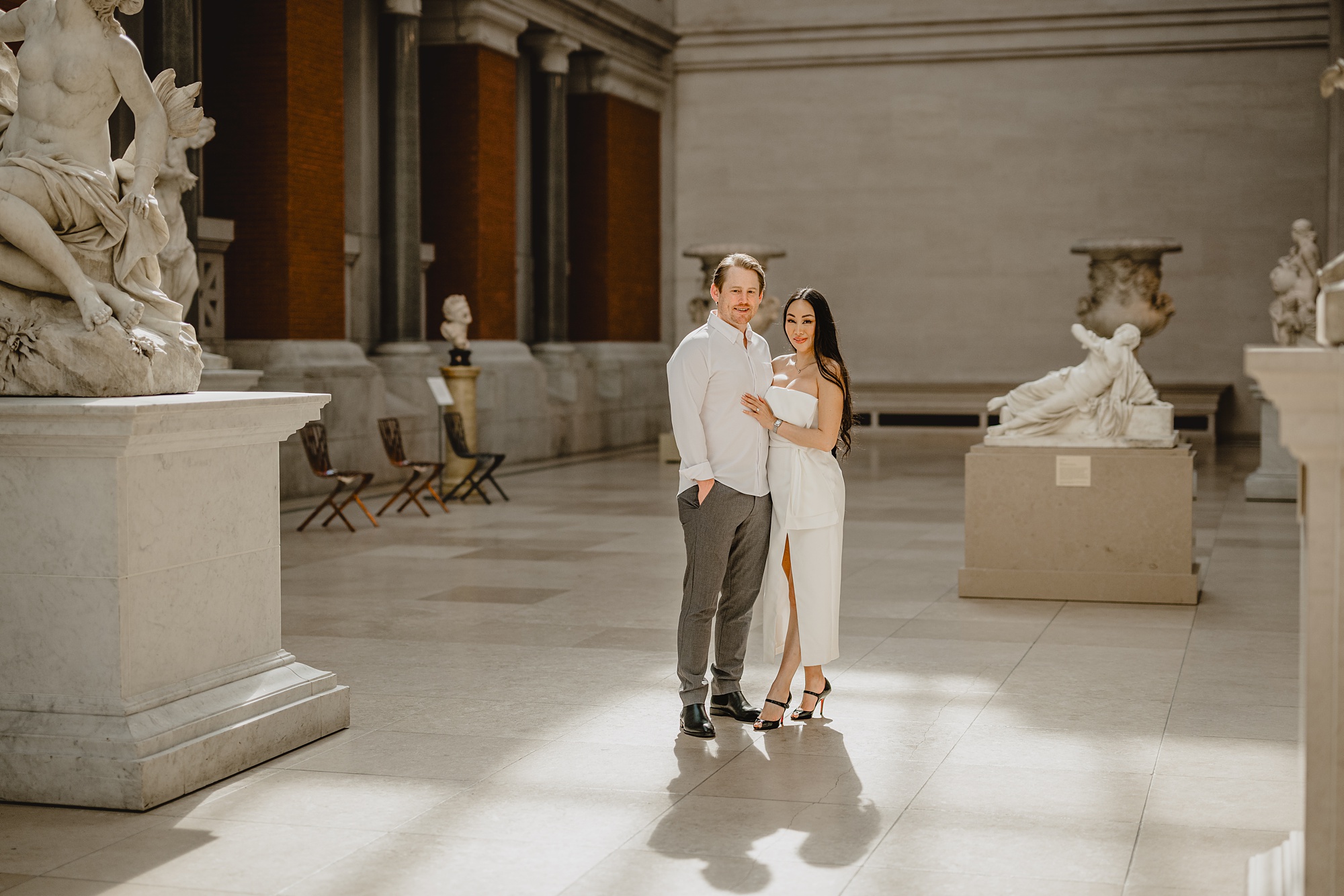 woman stands behind man inside exhibit at the Met Museum