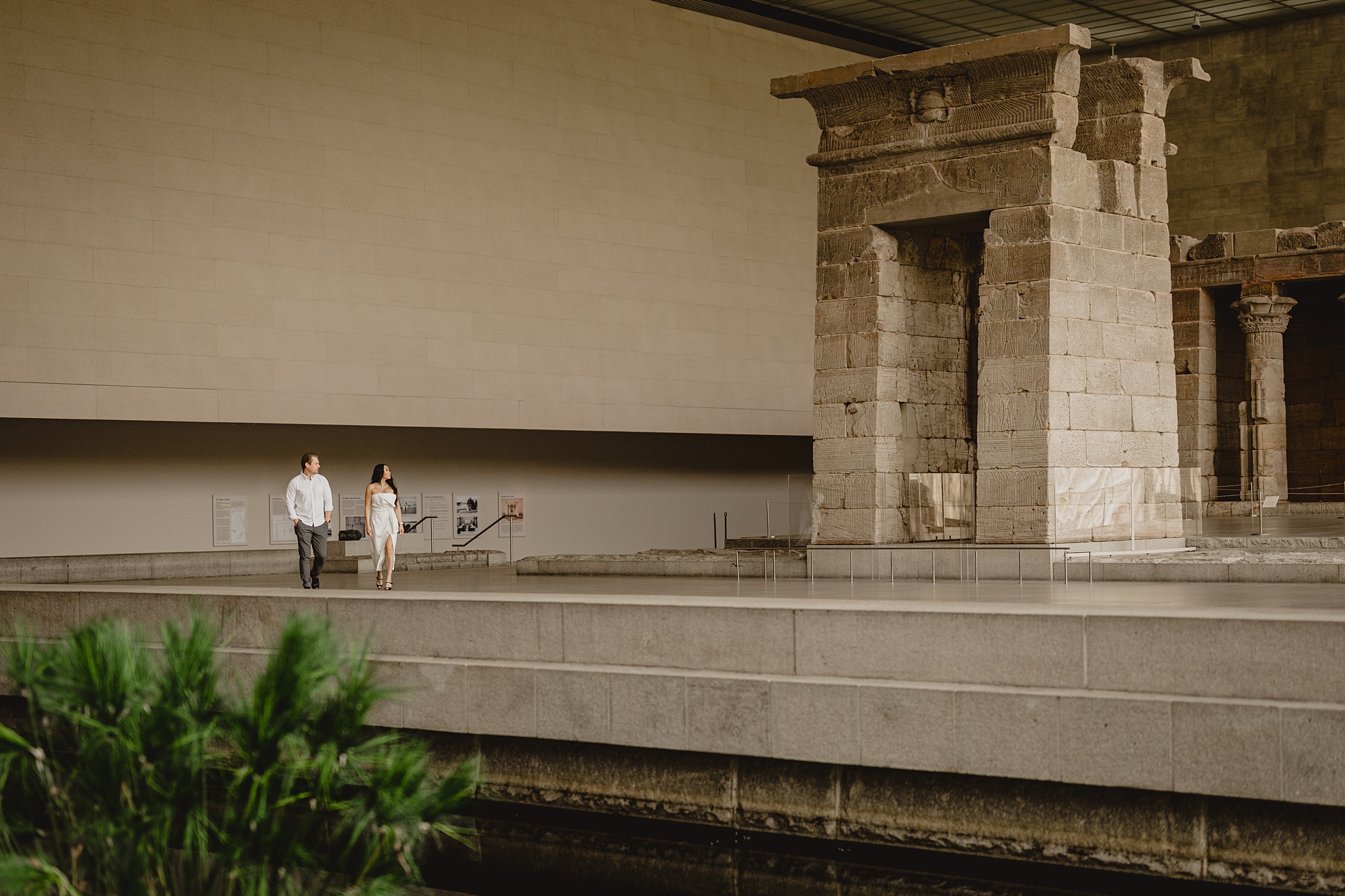 couple walks by water feature inside the Met Museum