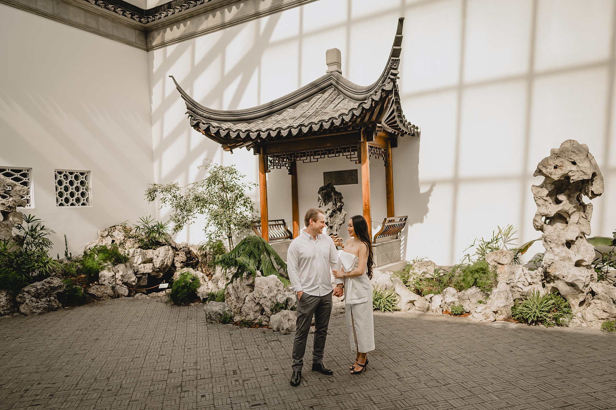 engaged couple stands outside Asian inspired doorway at the Met Museum
