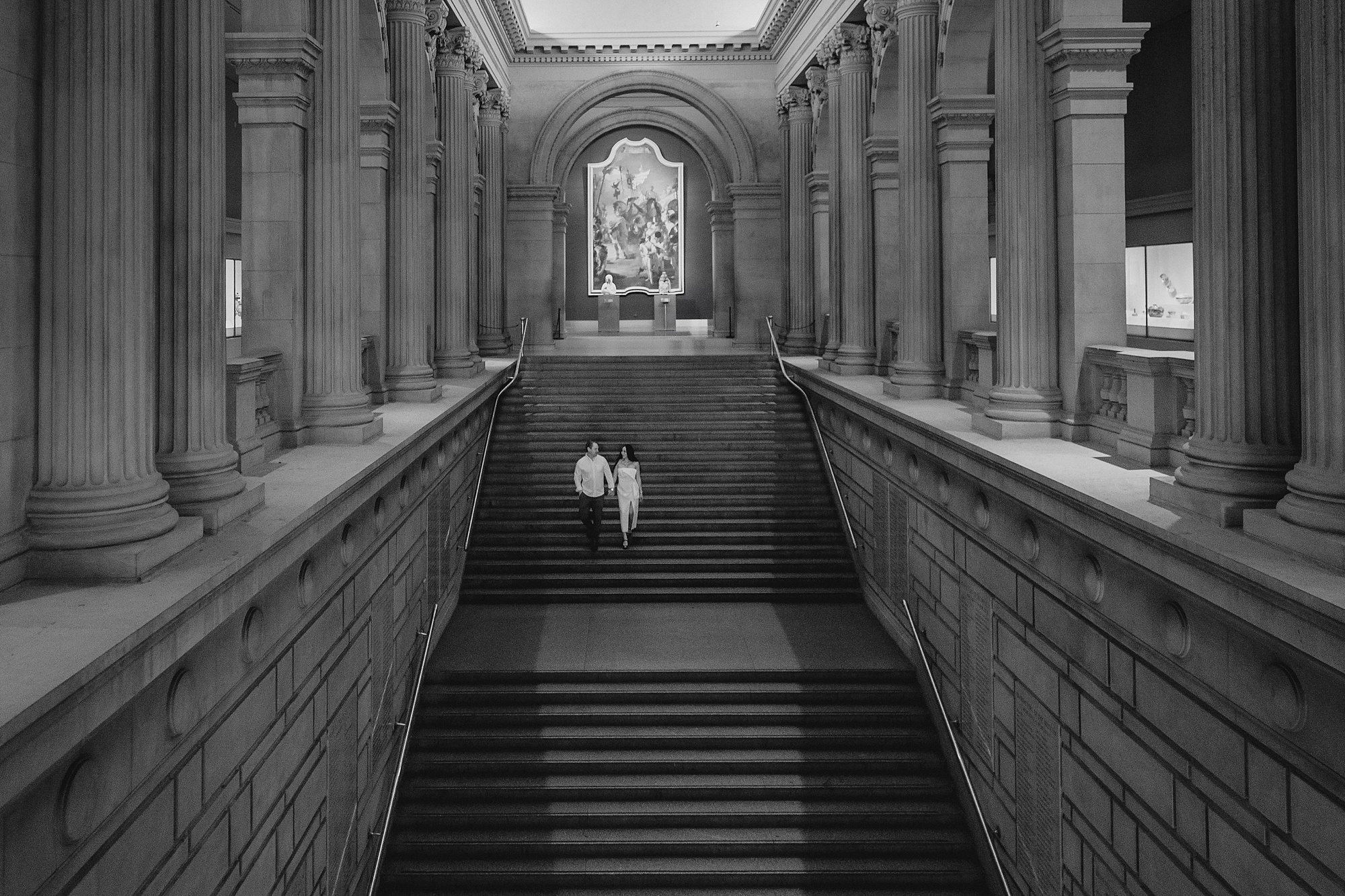 couple walks down steps inside NYC museum 