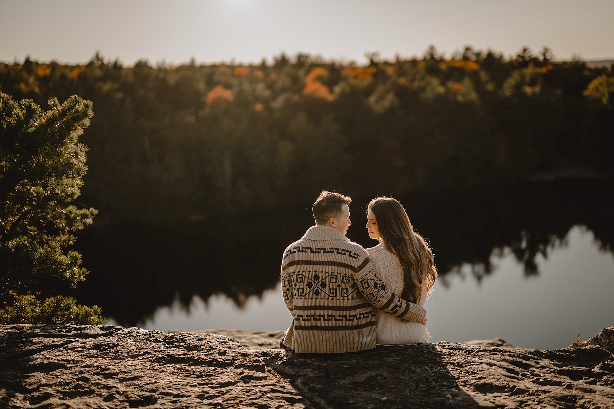 man and woman sit at top of Lake Minnewaska looking over the water