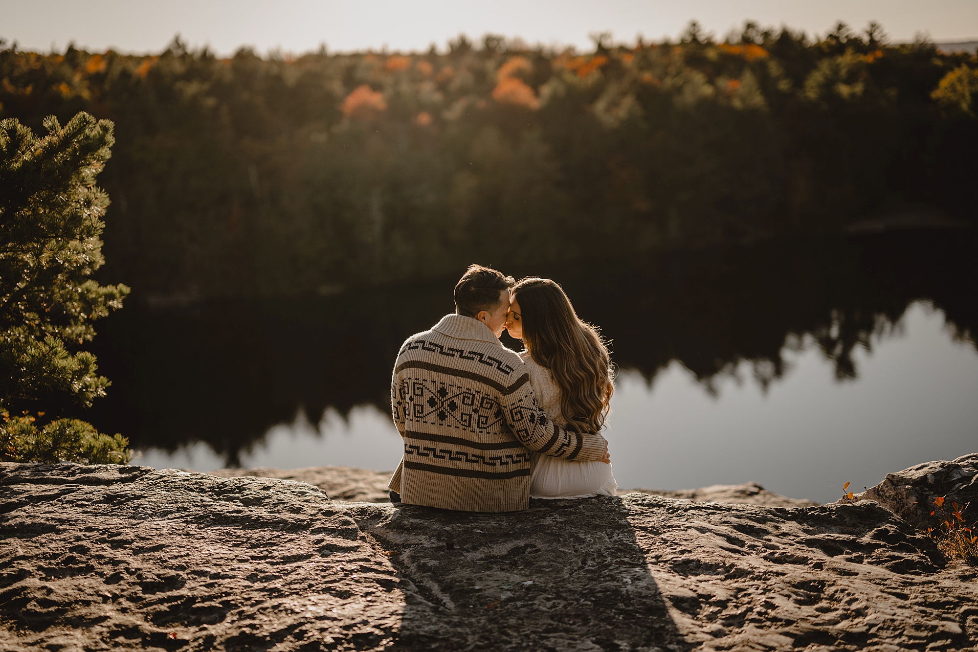 woman leans on man in cozy wool sweater overlooking water at Lake Minnewaska
