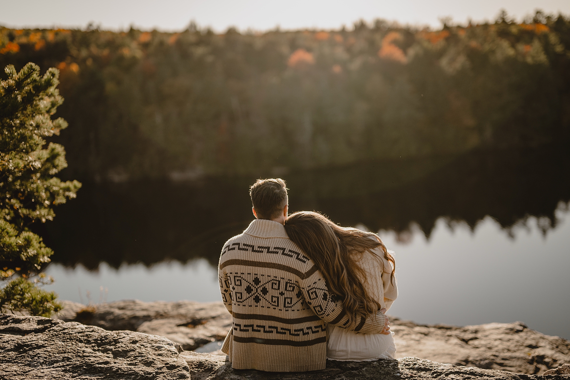 woman leans head on man's shoulder in cozy sweater for fall engagement session at Lake Minnewaska