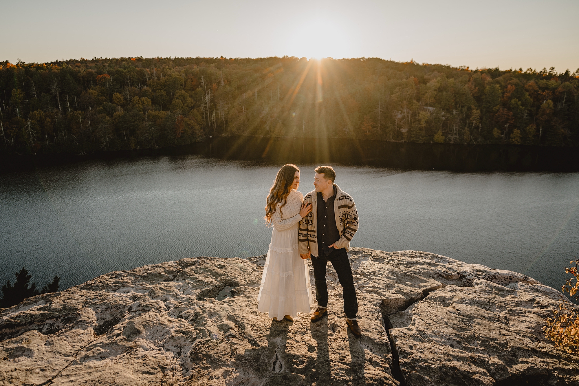 man and woman stand on top of cliff during Hudson Valley NY engagement session