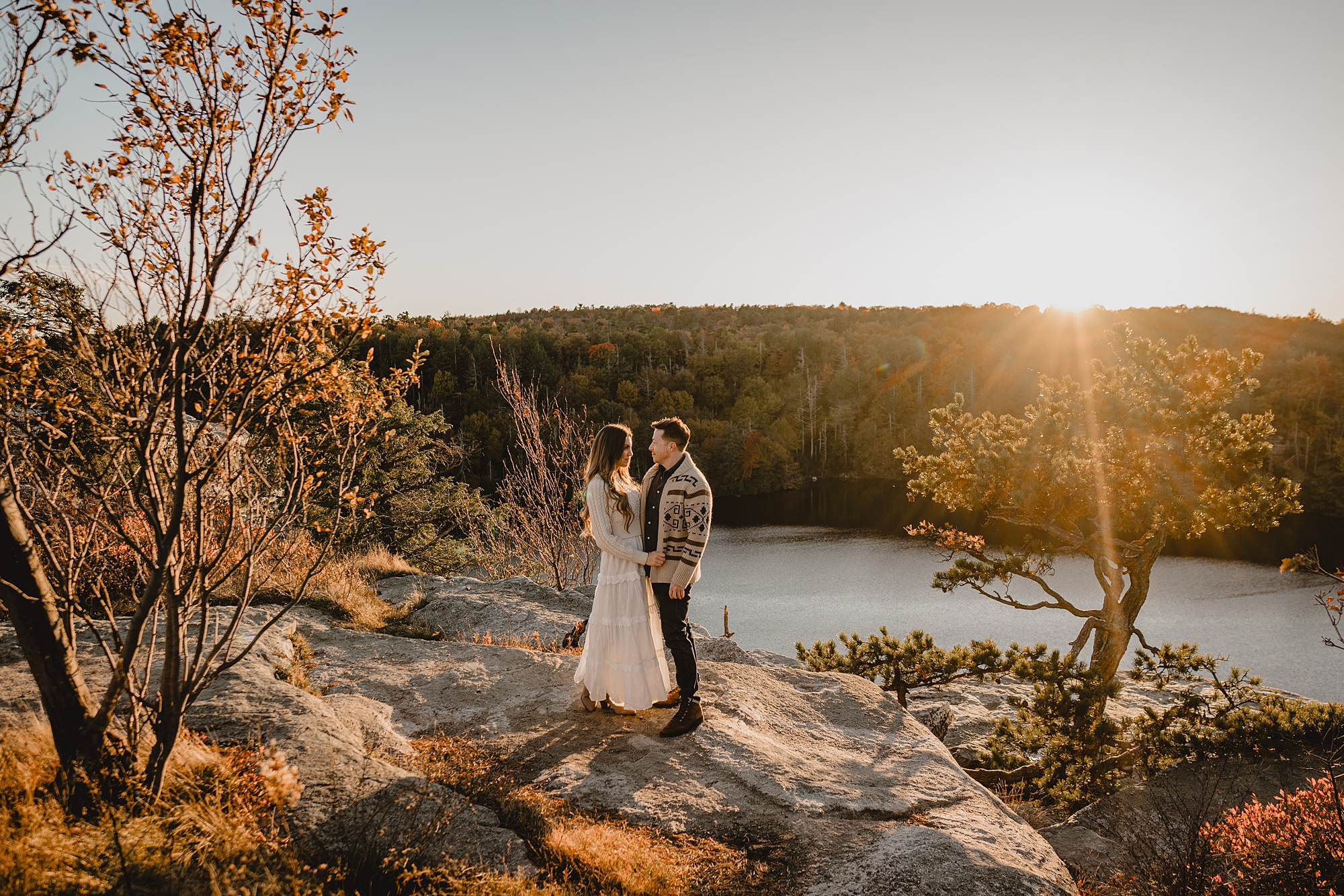 couple stands together on cliff for Hudson Valley NY engagement session