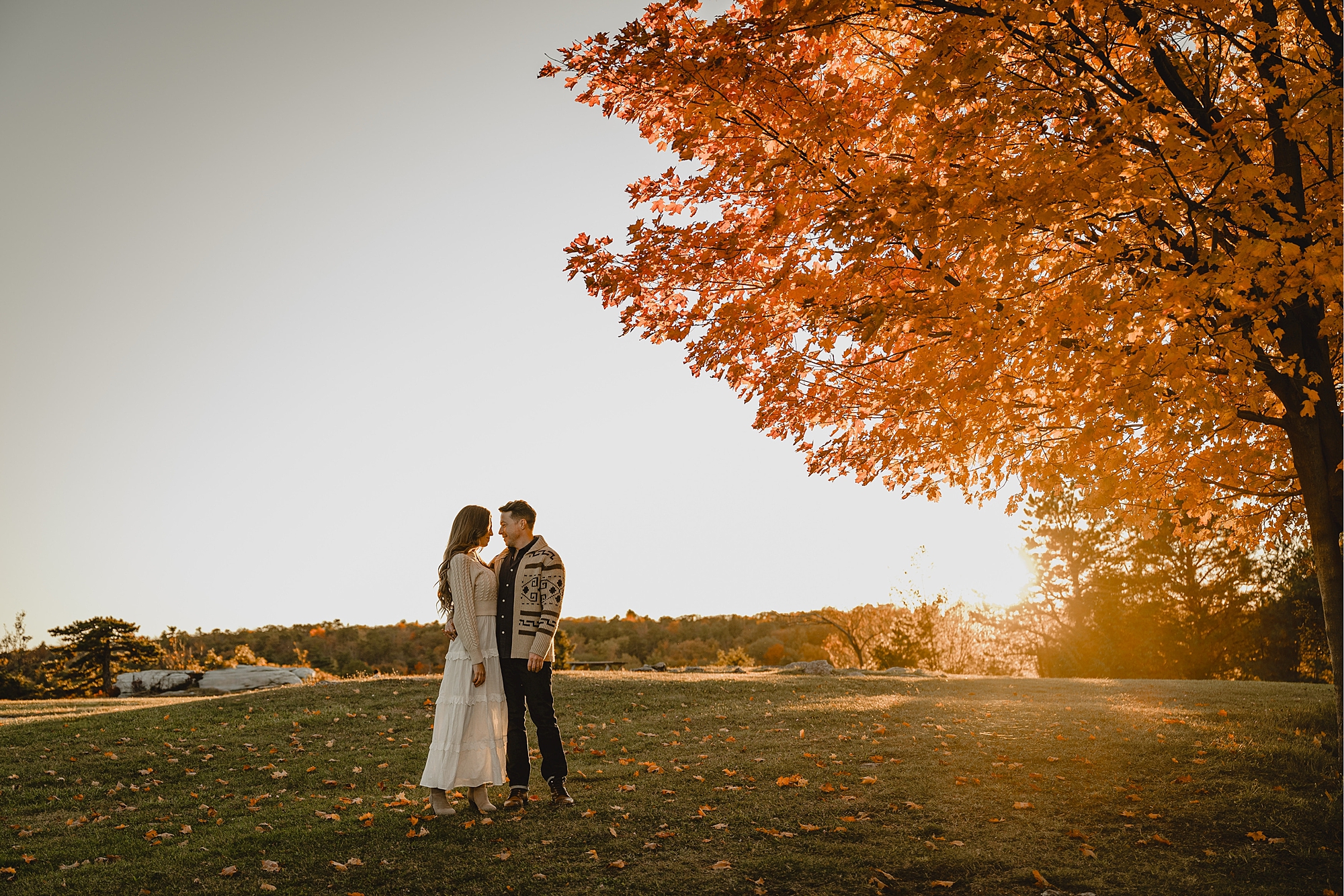 man and woman stand next to tree with orange leaves during Hudson Valley NY engagement session
